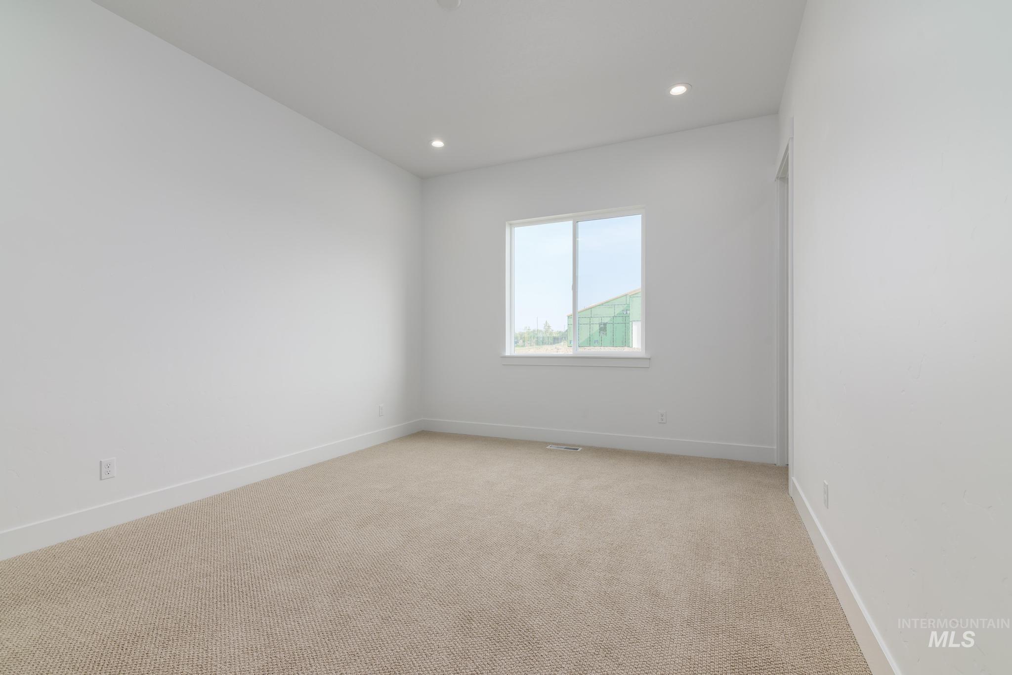 Empty room featuring light carpet and recessed lighting