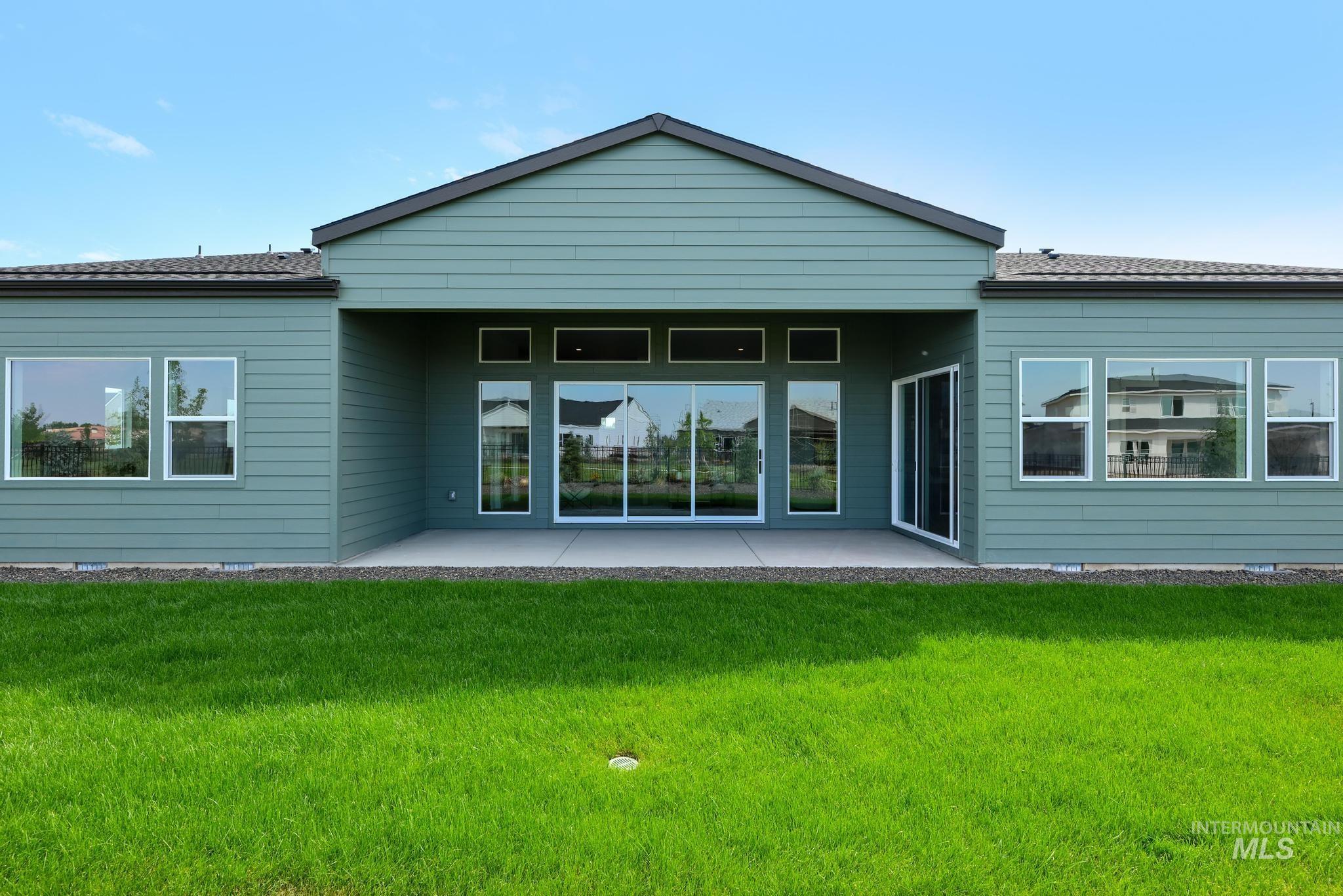 Rear view of property with a patio and a lawn