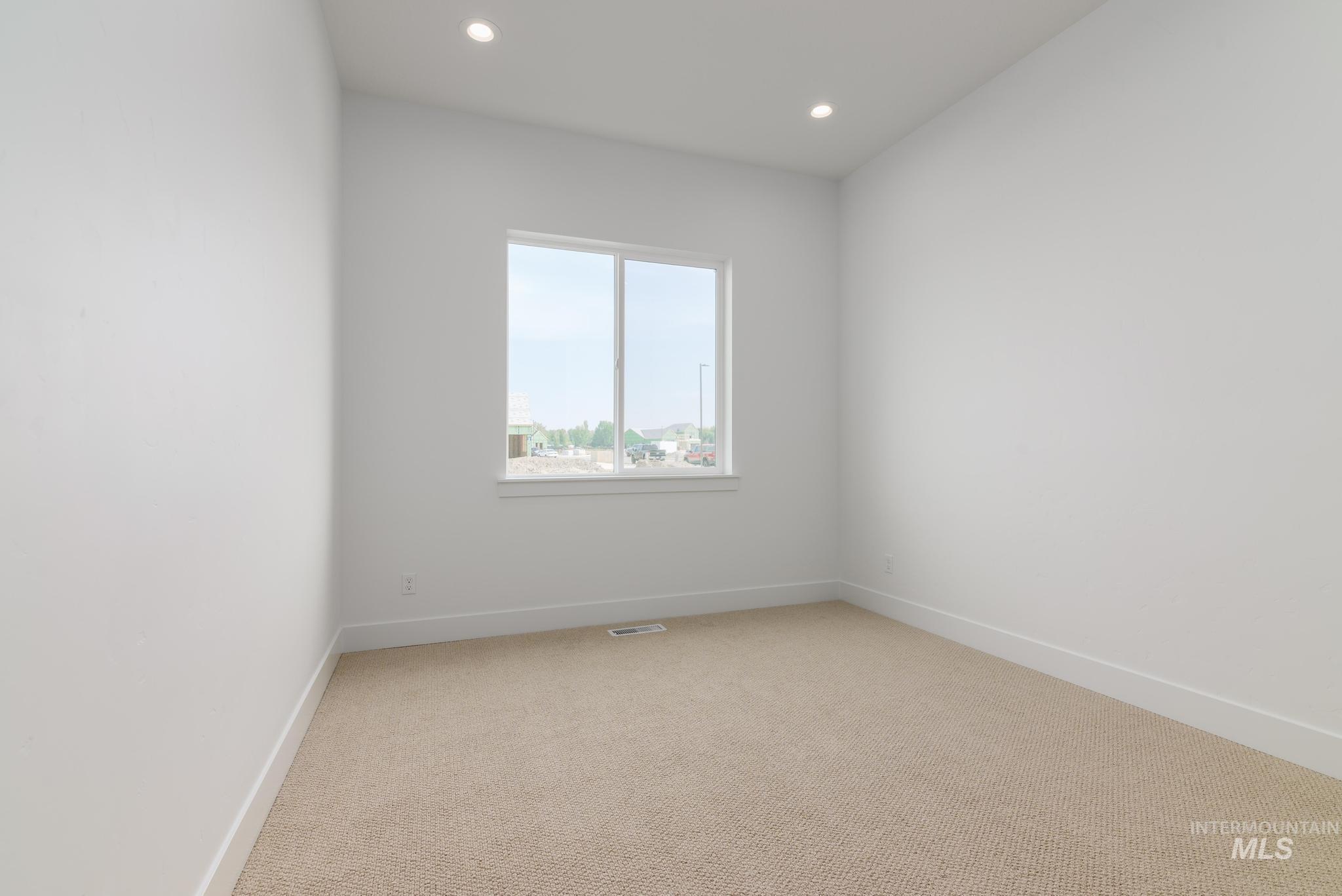 Empty room featuring light colored carpet and recessed lighting