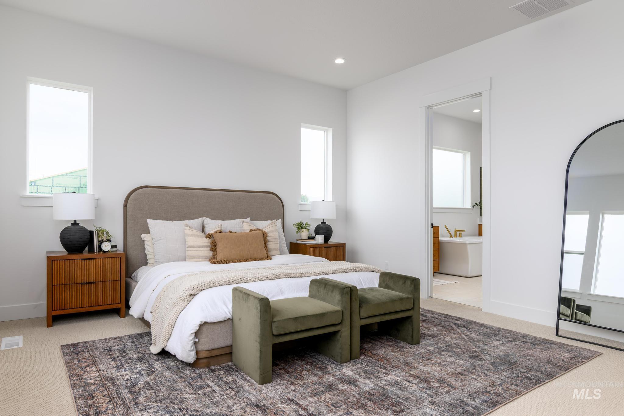 Carpeted bedroom featuring multiple windows, recessed lighting, and connected bathroom