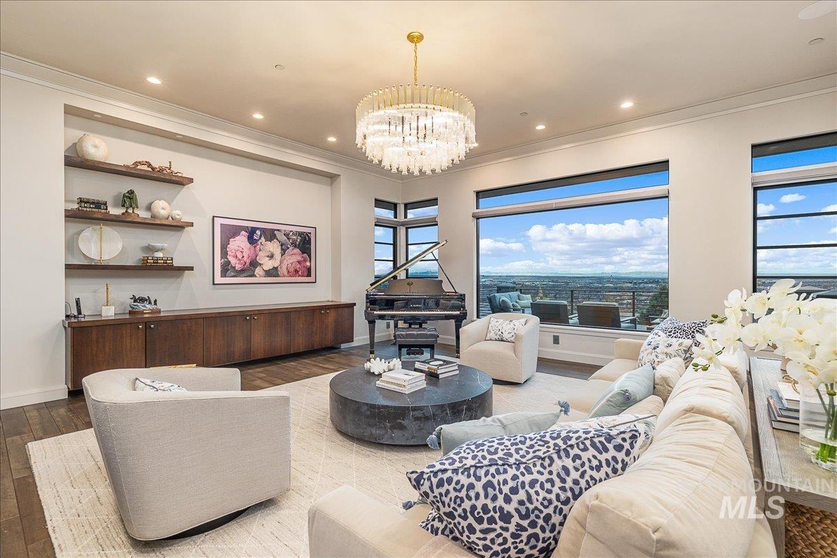 Living area featuring a chandelier, ornamental molding, wood finished floors, and recessed lighting