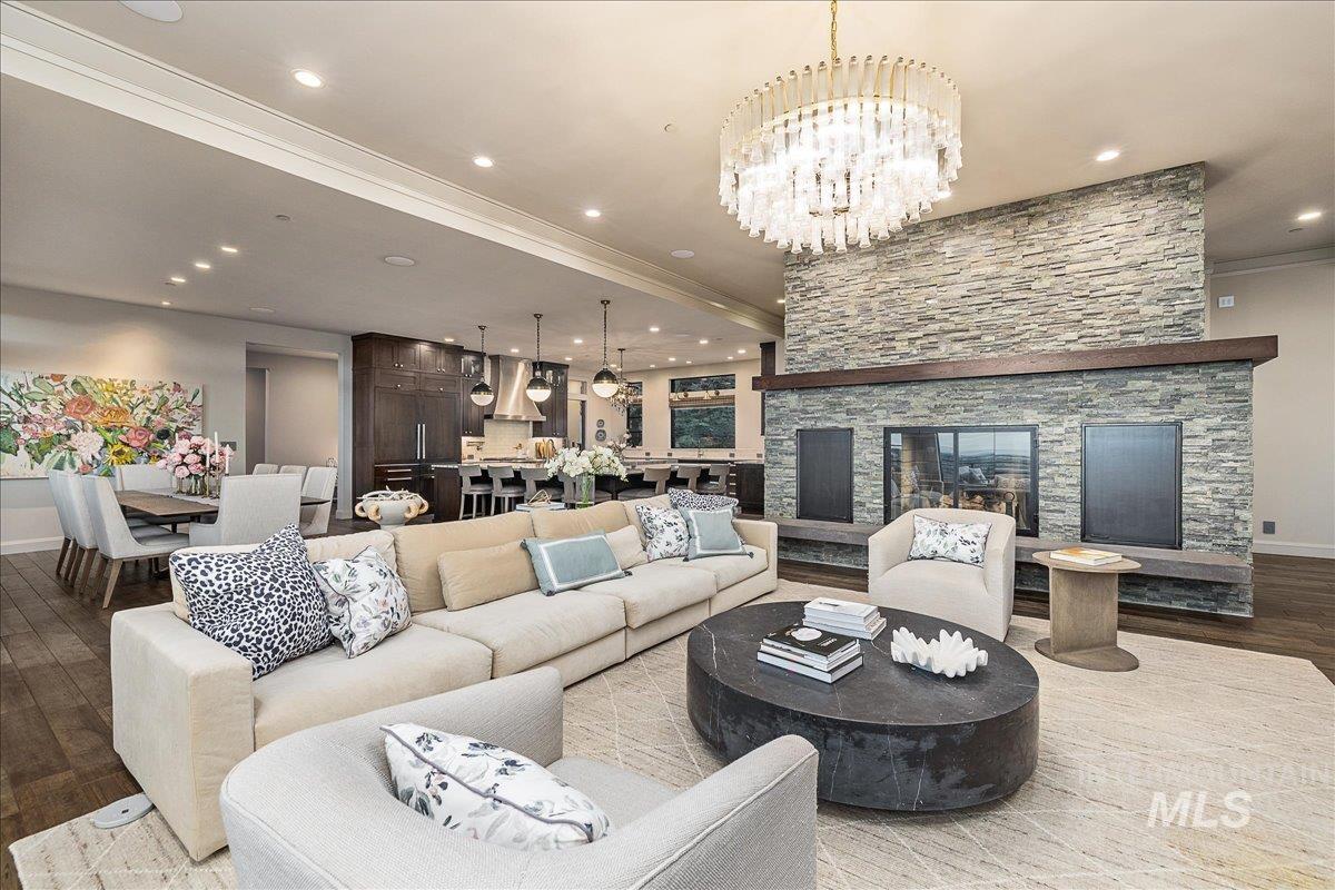 Living area featuring a chandelier, wood finished floors, recessed lighting, crown molding, and a fireplace
