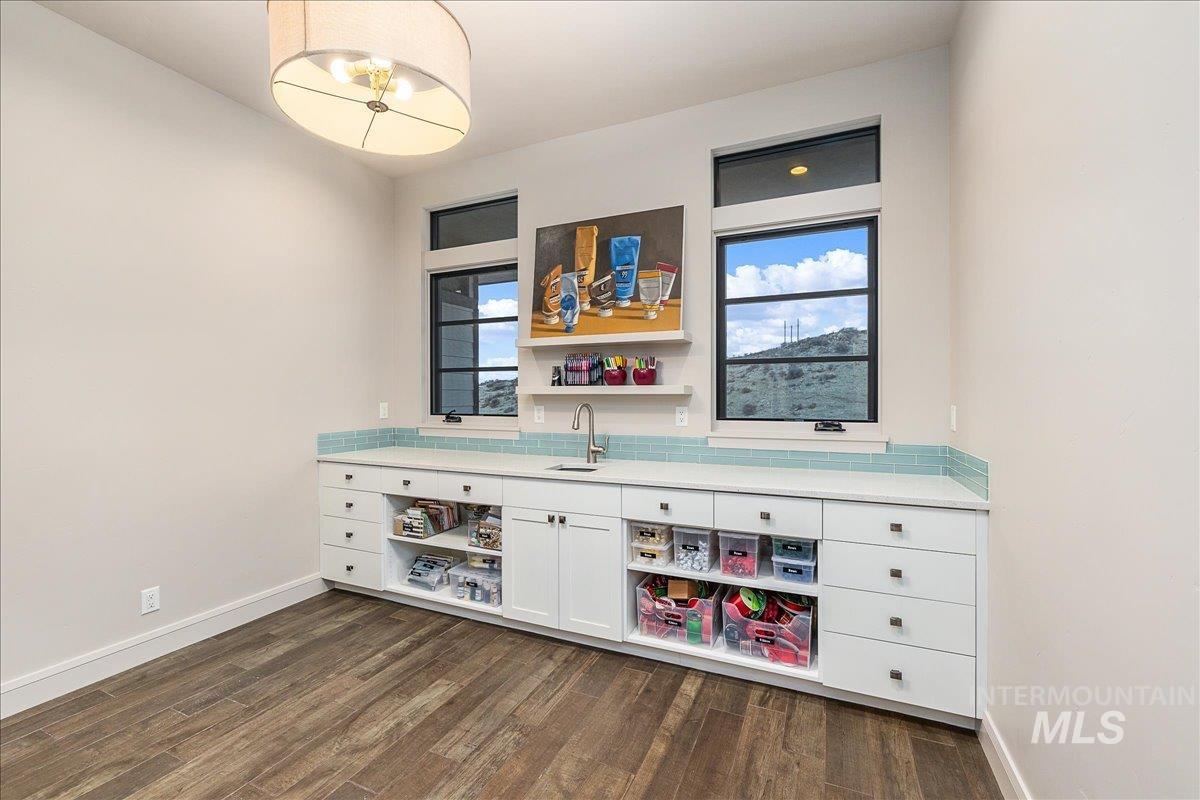 Bar with white cabinetry, open shelves, and dark wood-style floors