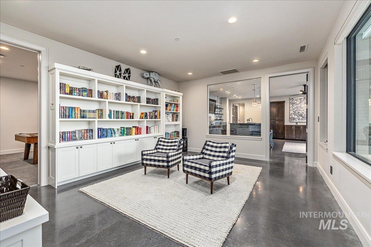 Living area with recessed lighting and finished concrete flooring