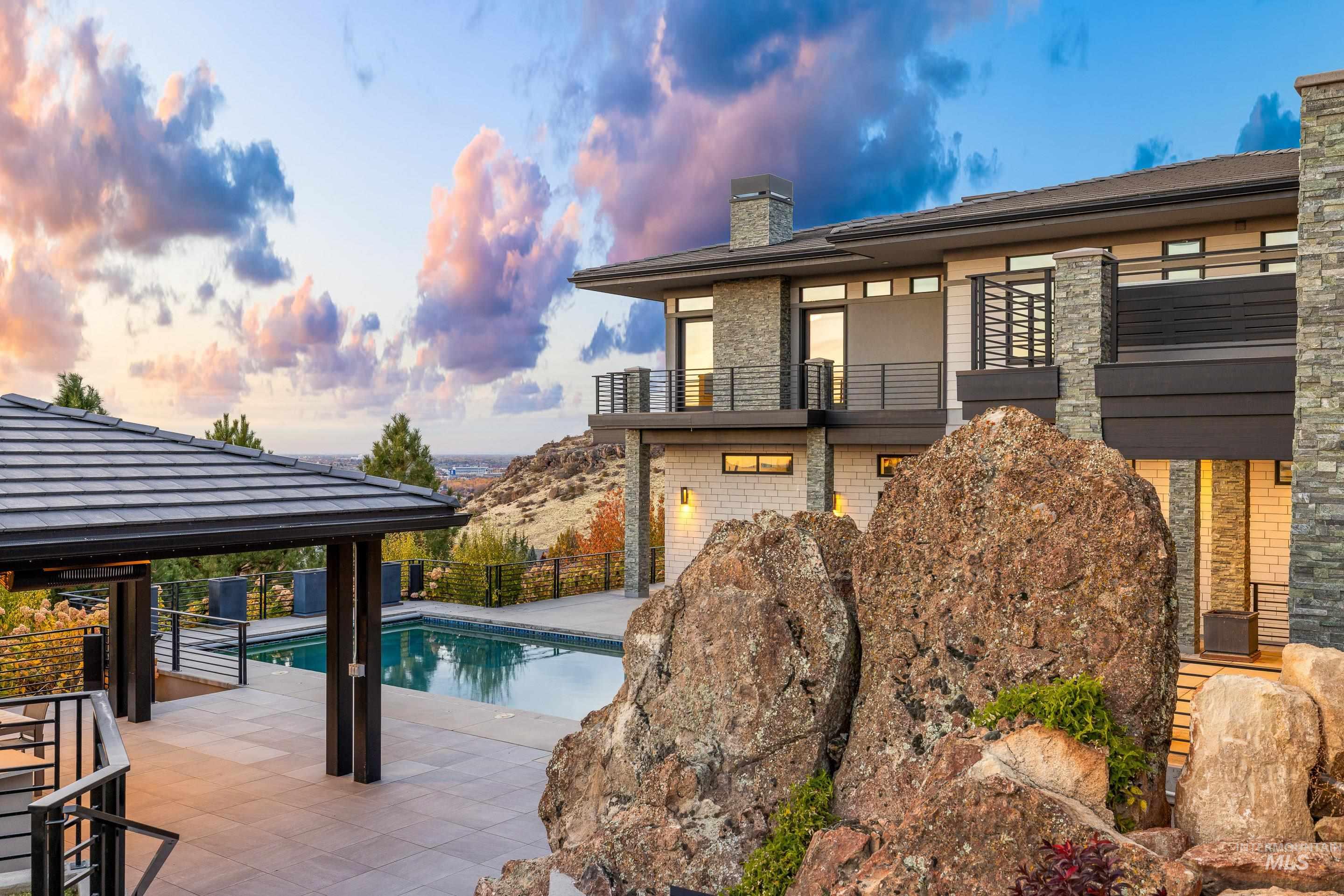 Pool at dusk featuring a patio and a balcony
