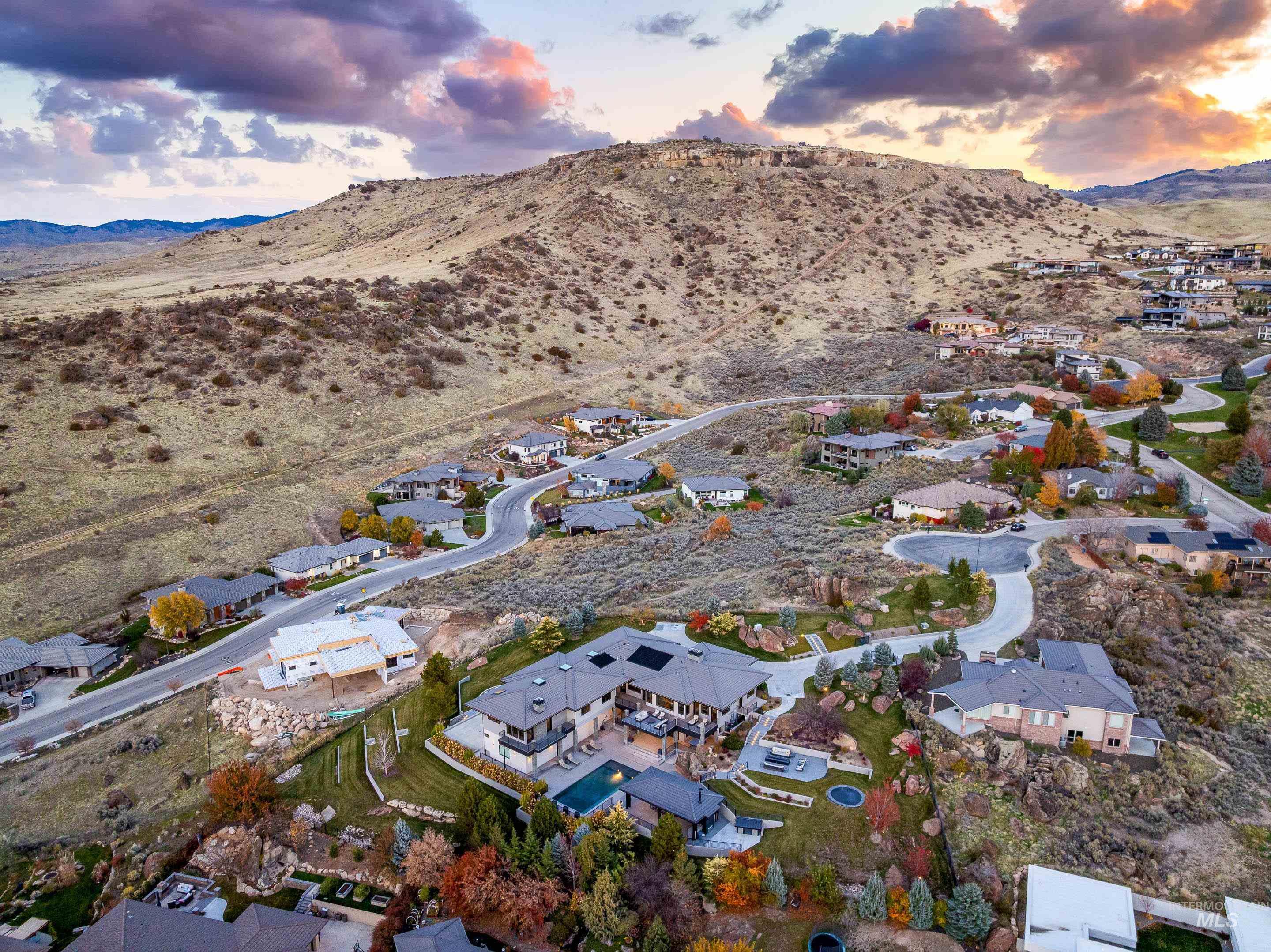 Aerial overview of property's location with nearby suburban area and a mountainous background