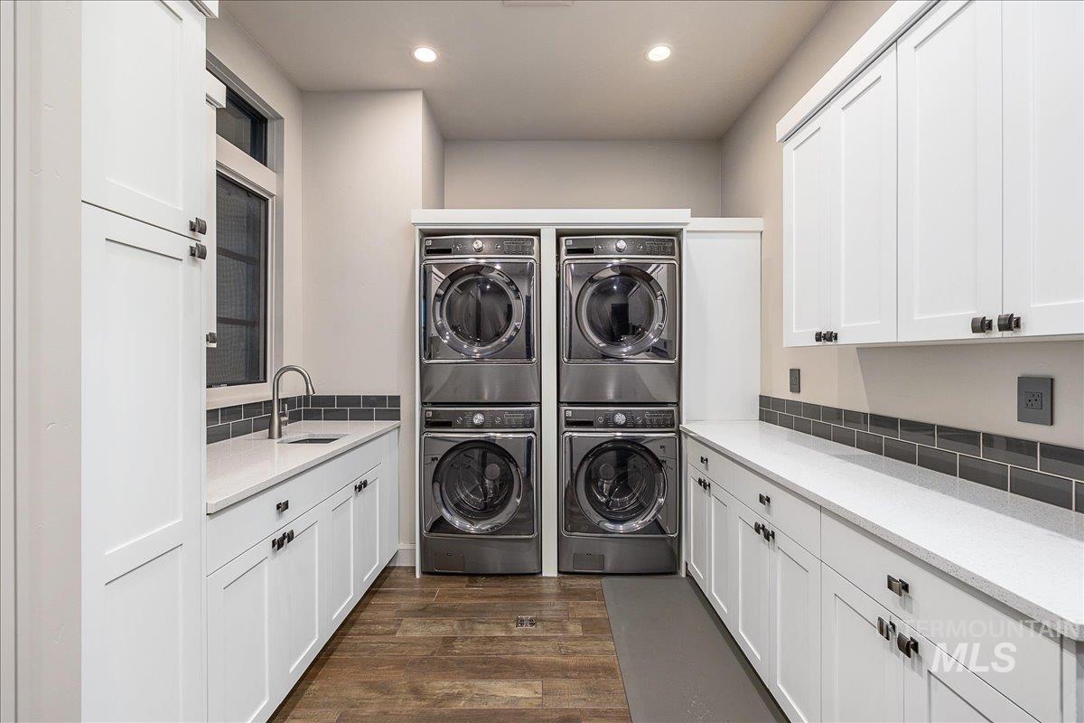 Laundry area featuring cabinet space, dark wood-type flooring, and recessed lighting