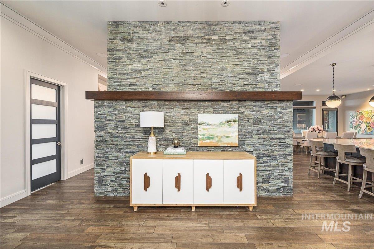 Interior space featuring white cabinets, ornamental molding, pendant lighting, and dark wood finished floors
