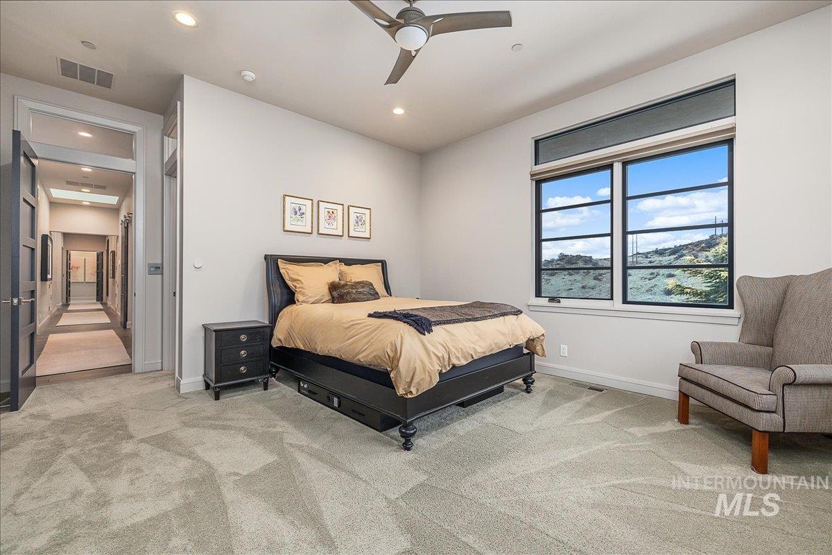 Bedroom with light carpet, a ceiling fan, and recessed lighting
