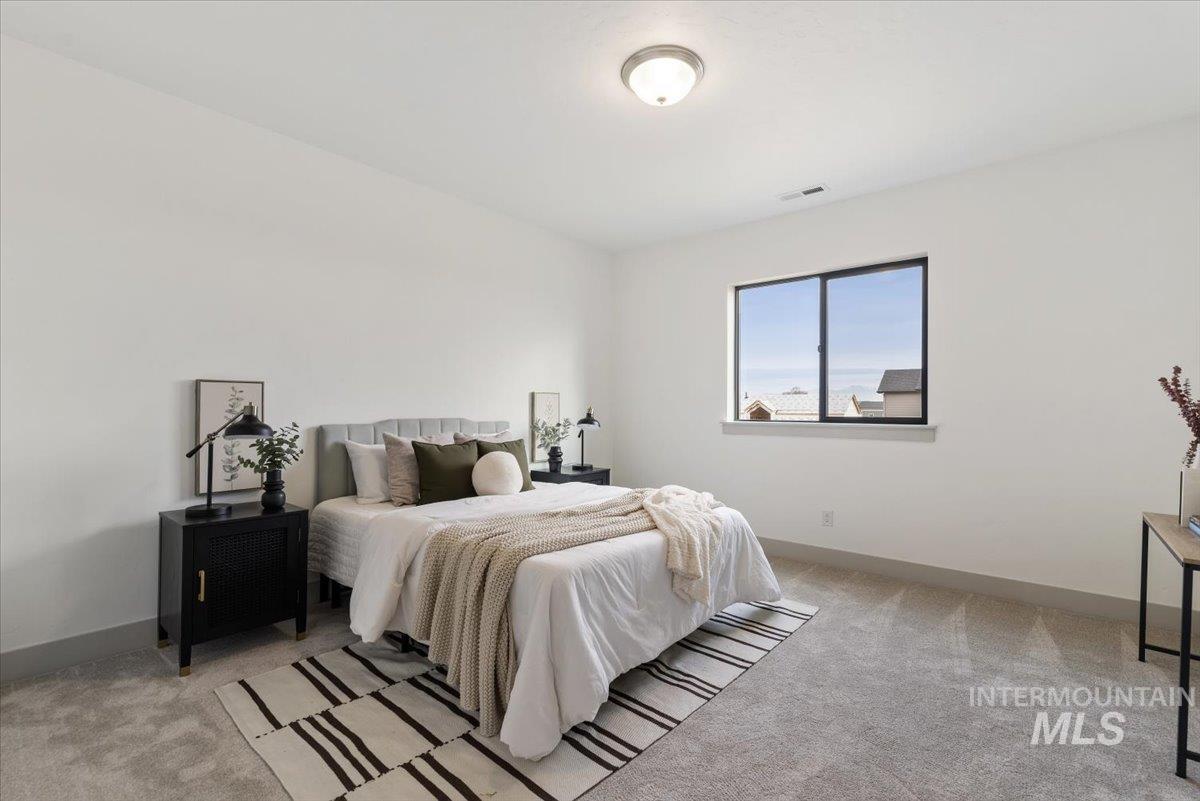 Bedroom with light colored carpet and baseboards