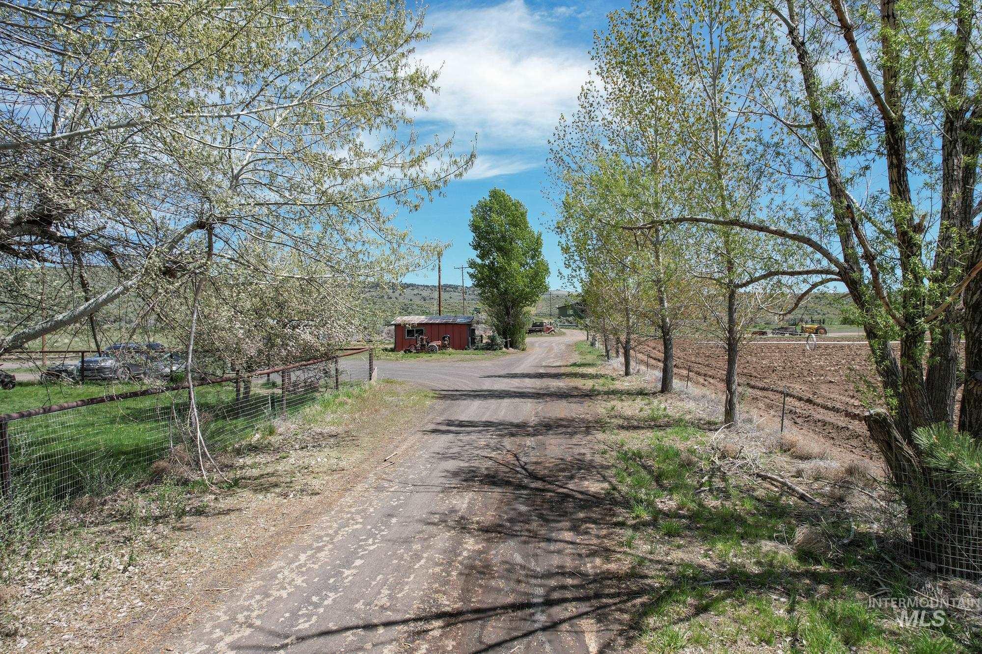 View of dirt / gravel driveway featuring a view of countryside