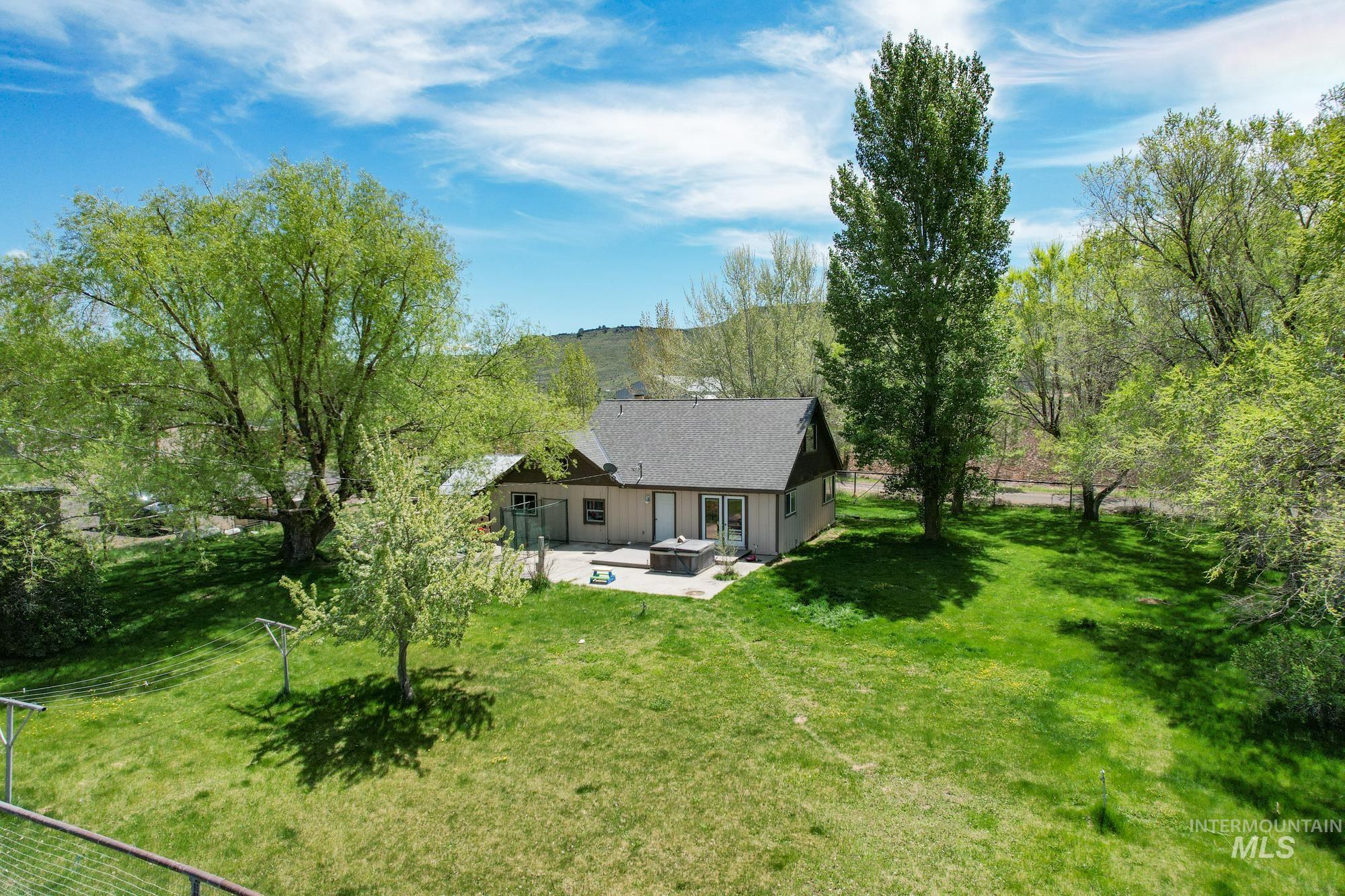 View of grassy yard with a patio and an outdoor fire pit