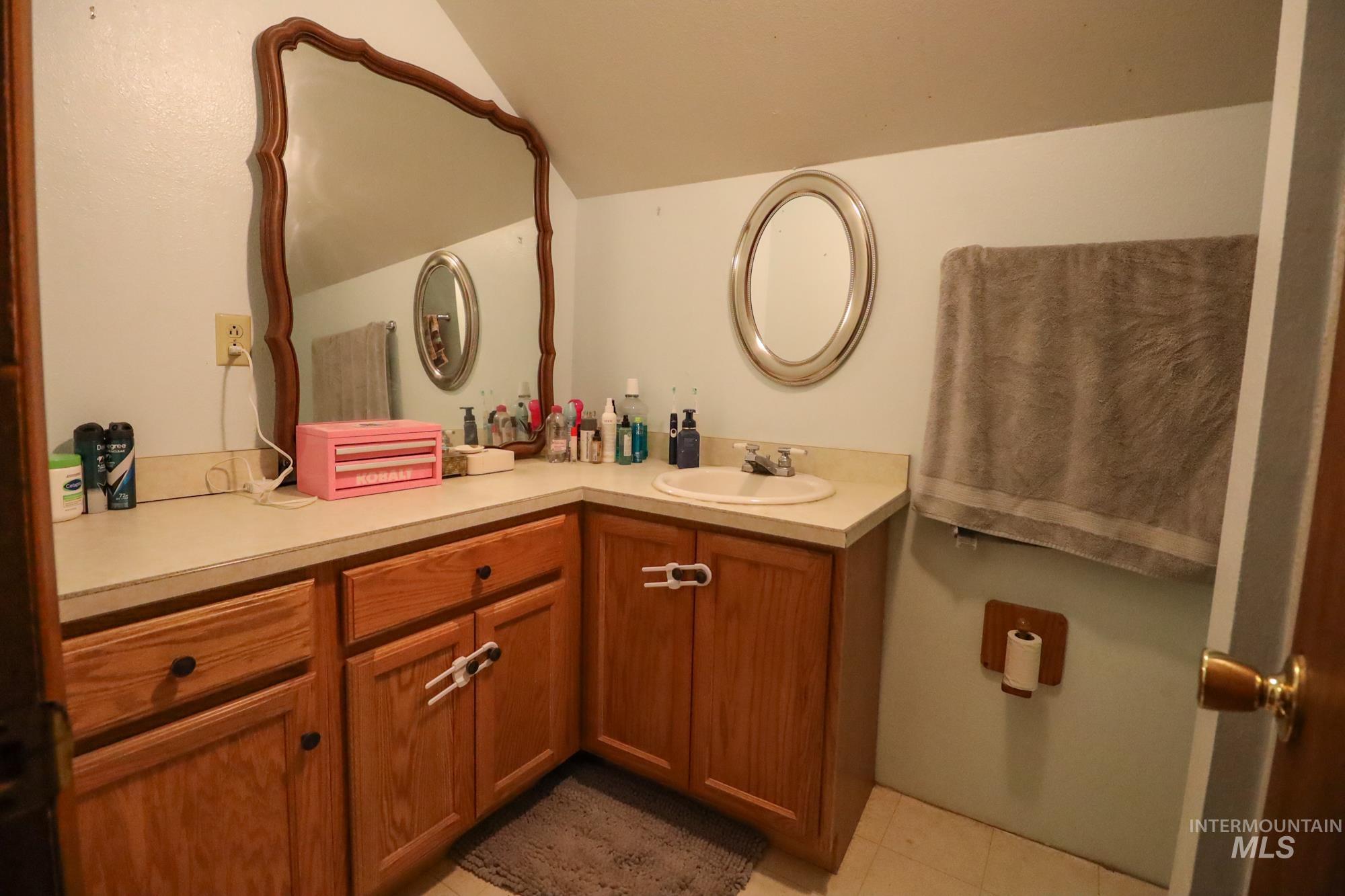 Bathroom featuring vanity and vaulted ceiling