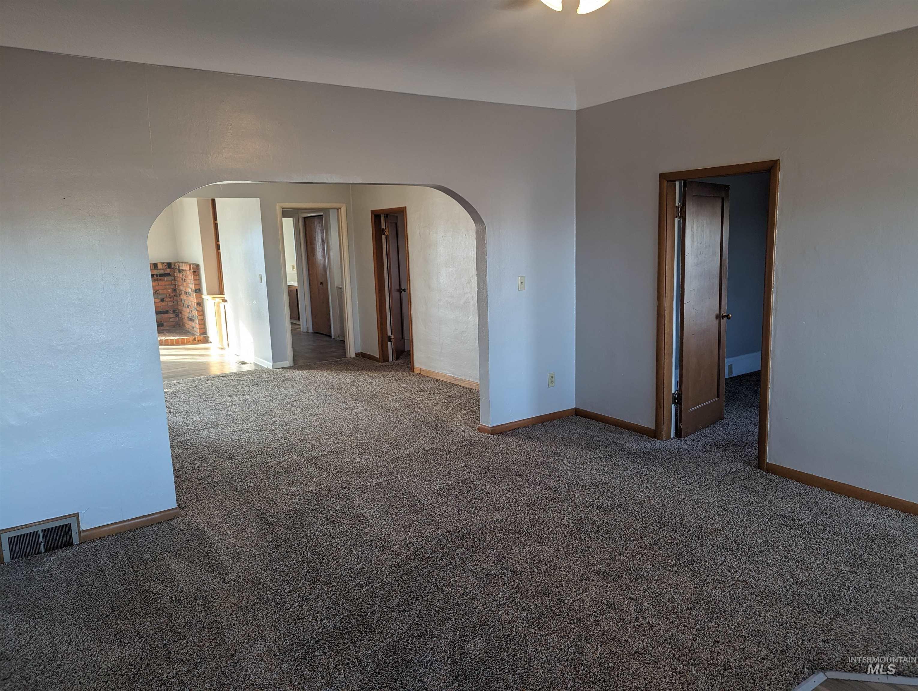 Empty room with carpet floors and arched walkways
