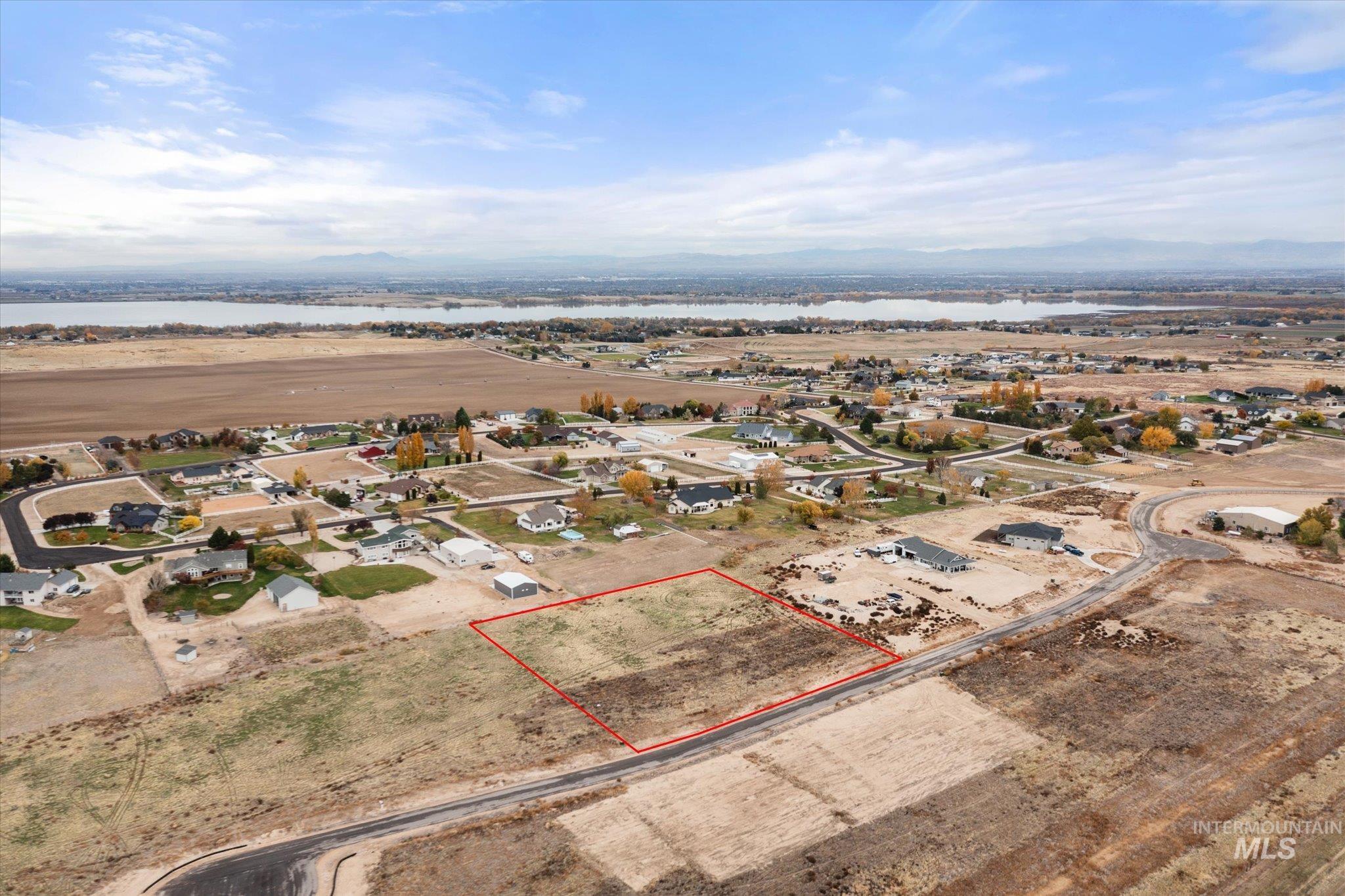 Aerial view of residential area with property parcel outlined and a nearby body of water