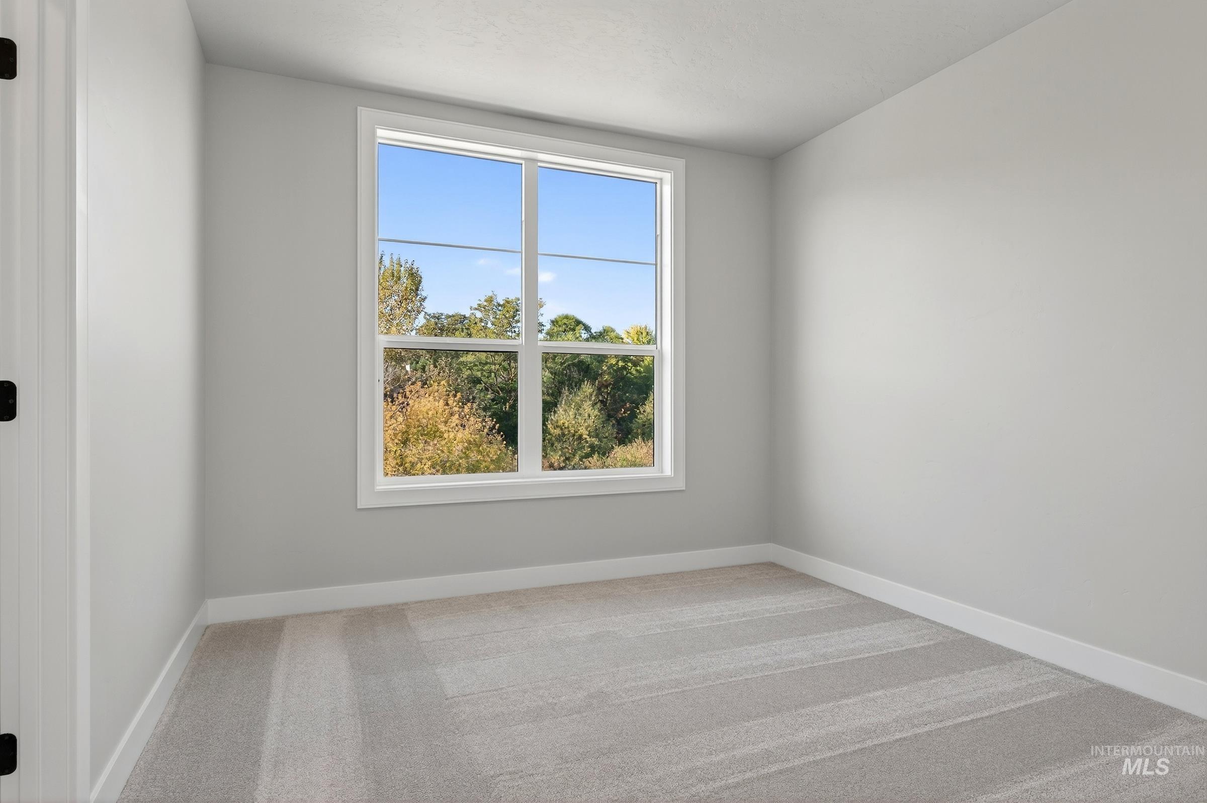 Empty room with light carpet and baseboards