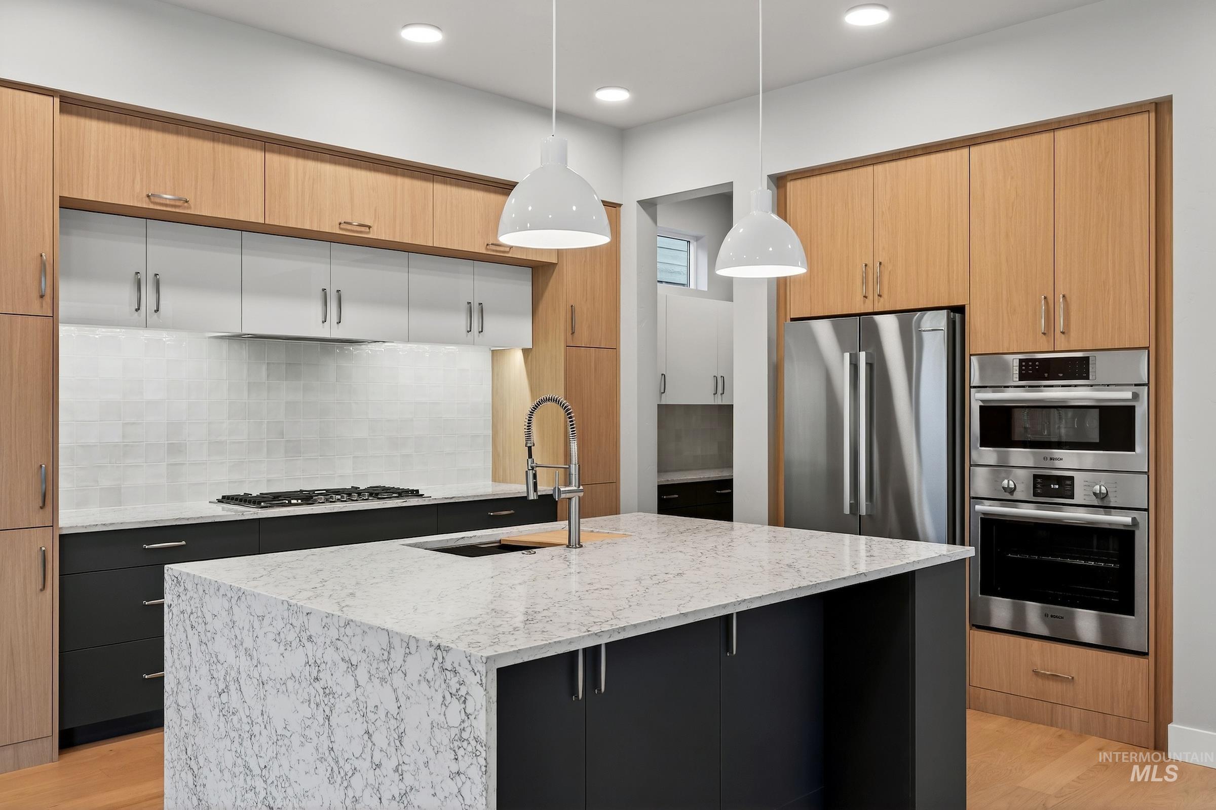 Kitchen featuring light wood-style floors, pendant lighting, backsplash, light stone countertops, and recessed lighting