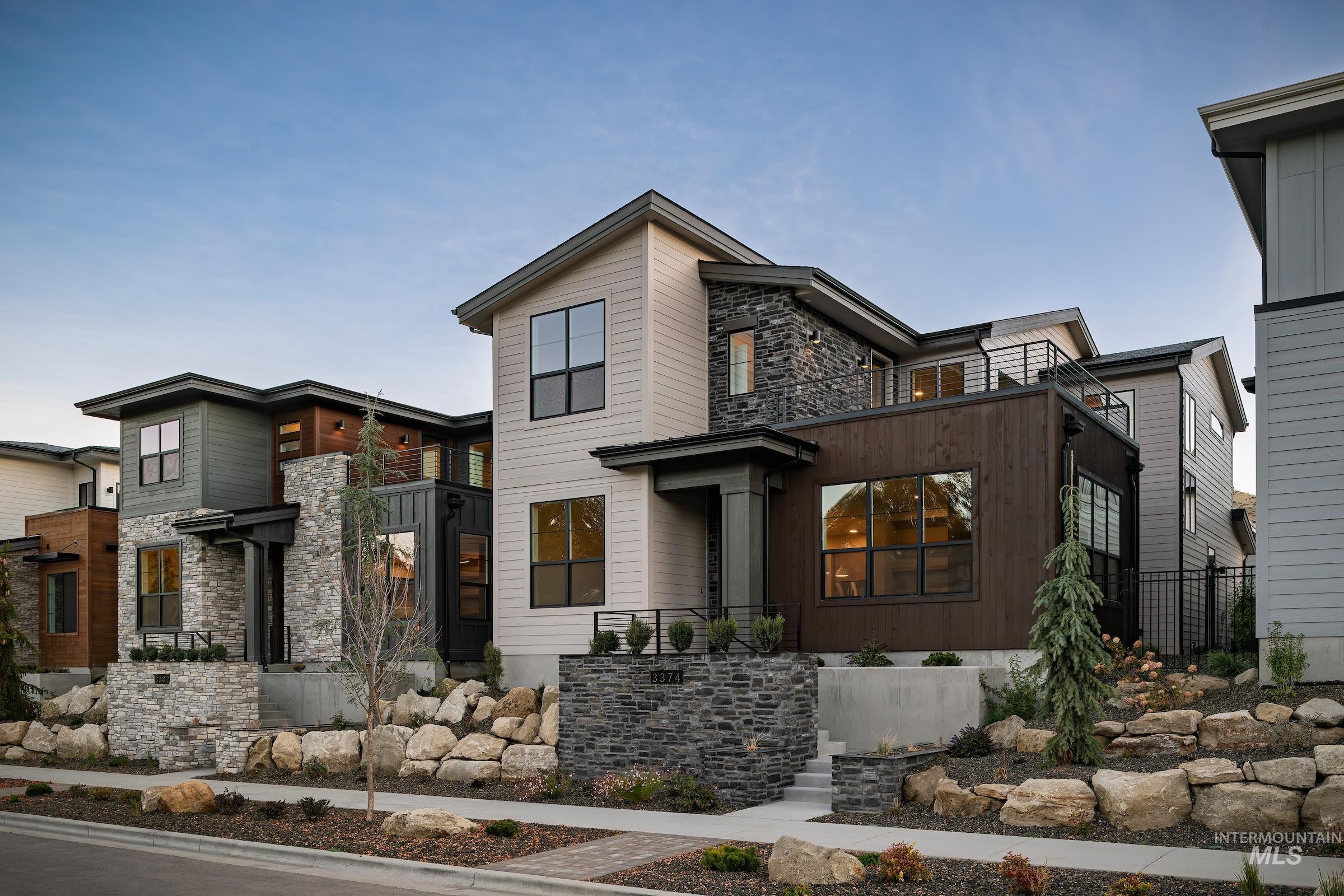 Modern home with stone siding and a balcony