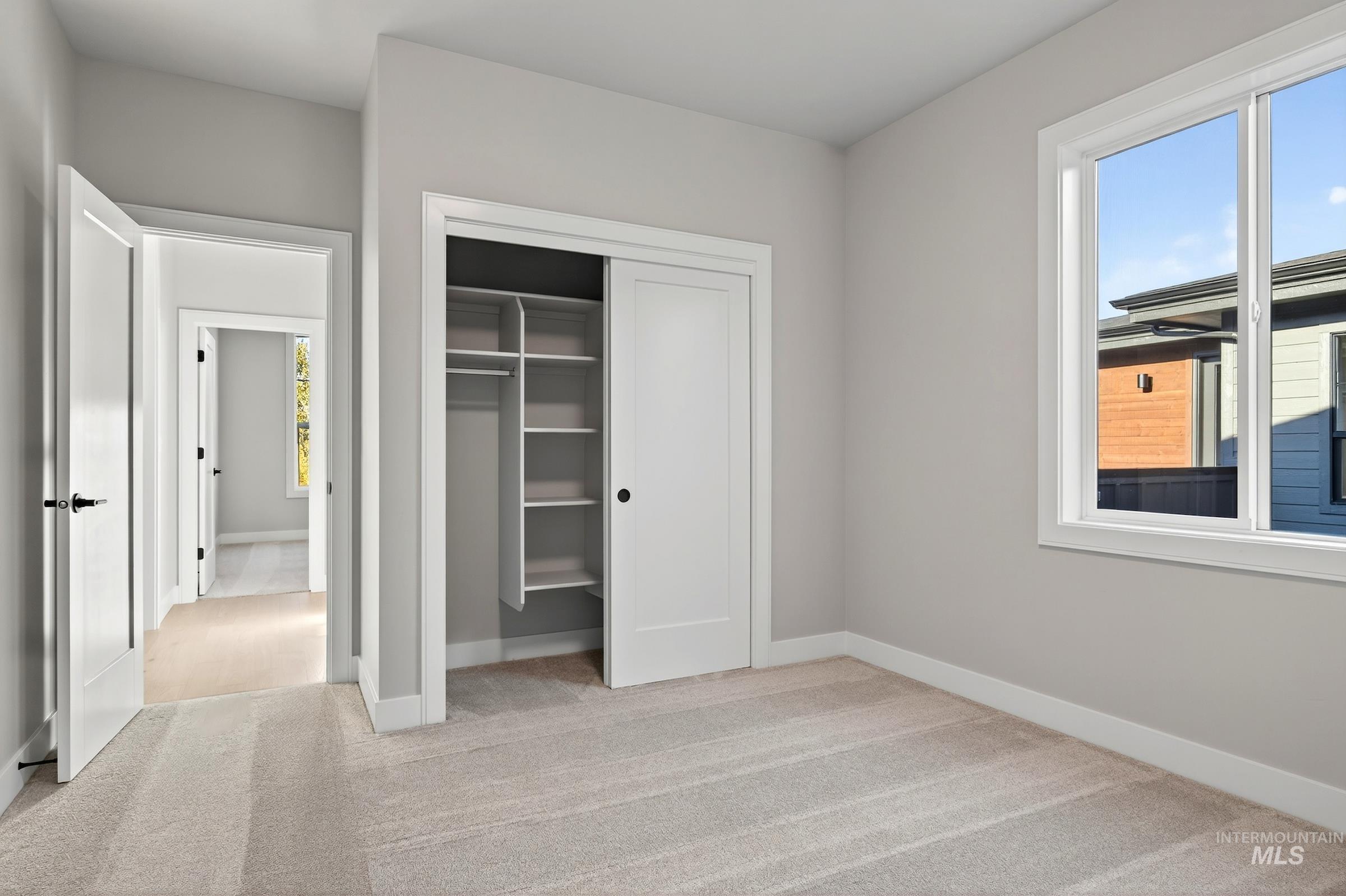Unfurnished bedroom with light colored carpet and a closet