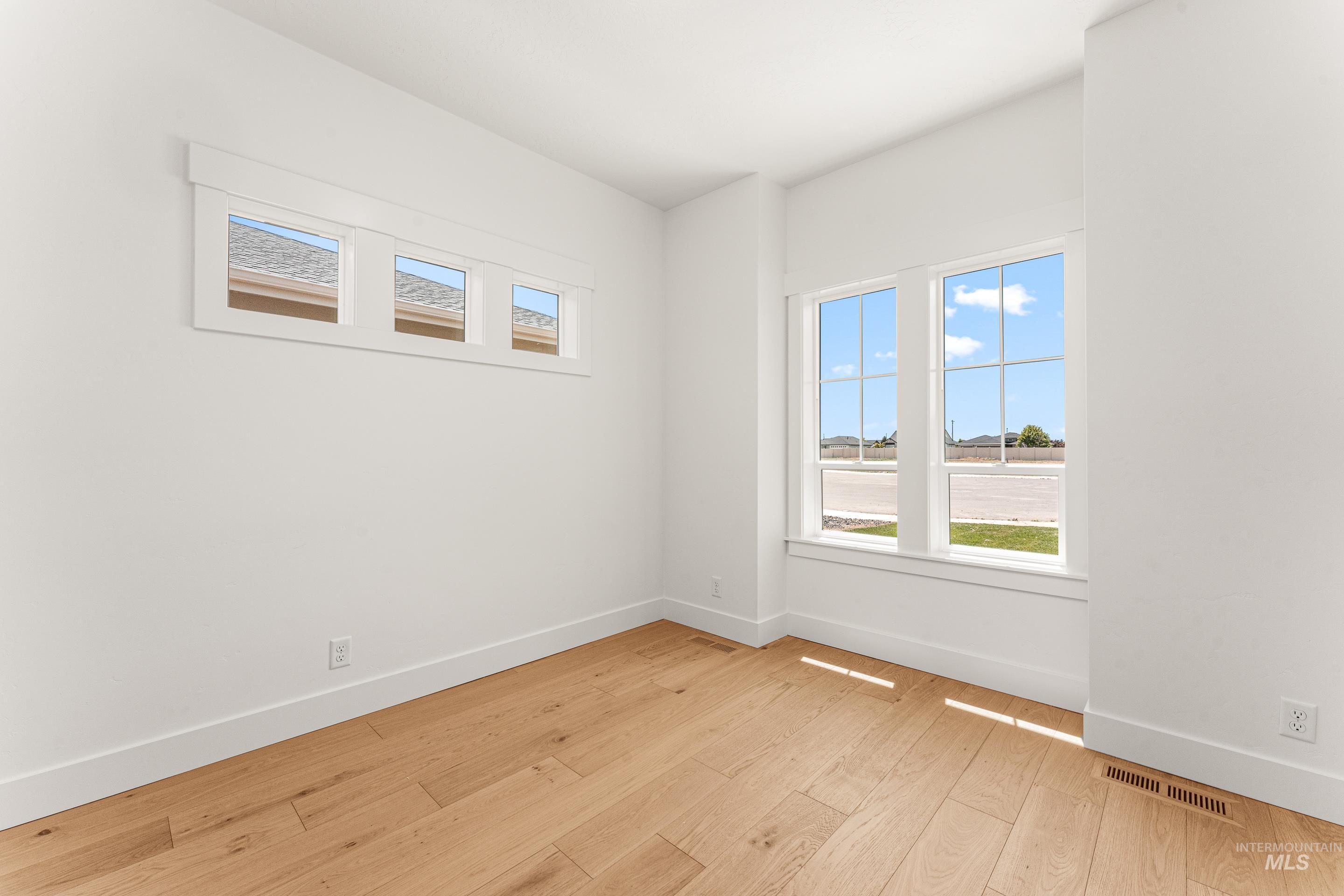 Unfurnished room with plenty of natural light and light wood-style flooring