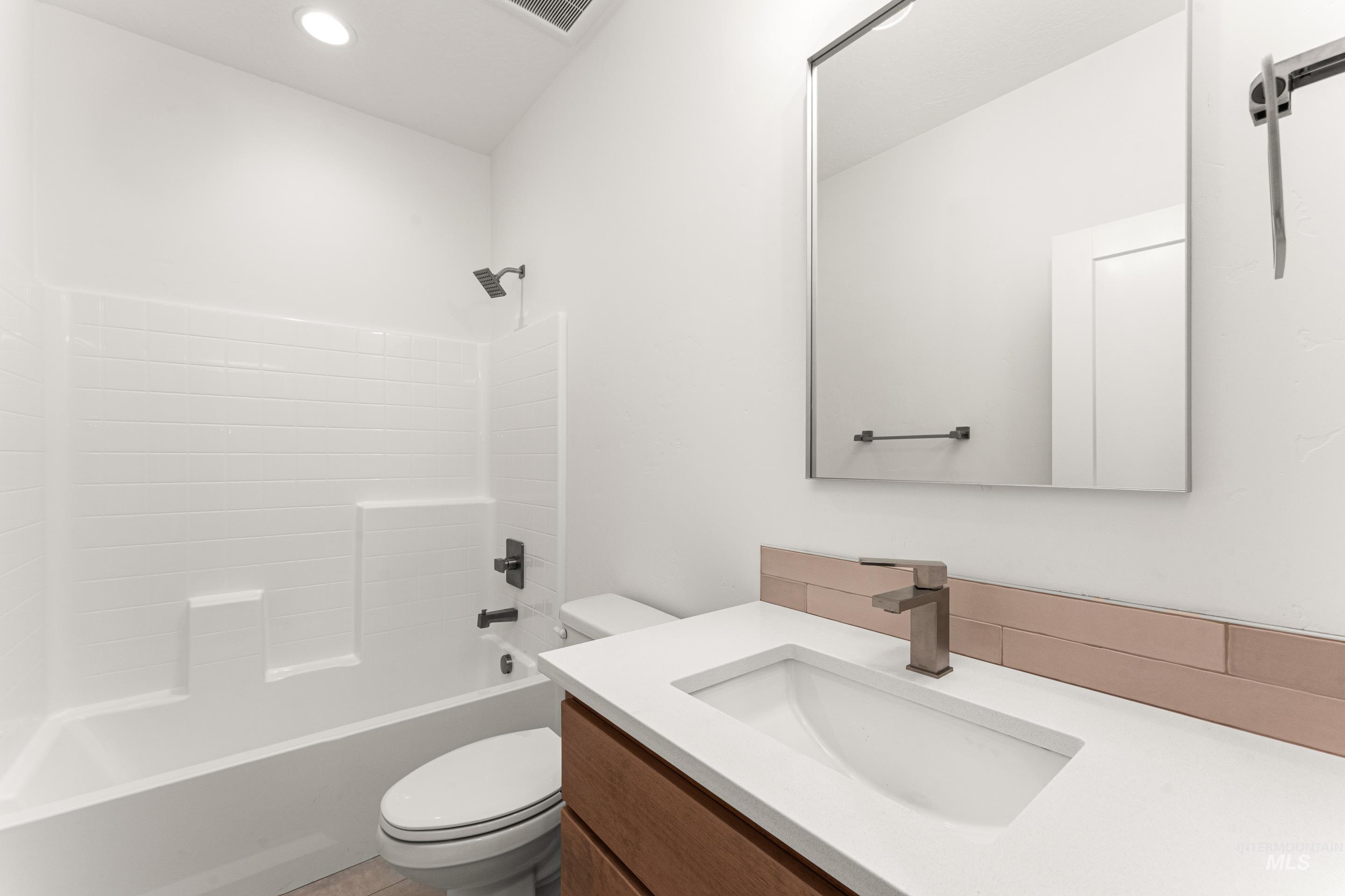 Bathroom with  shower combination, vanity, light tile patterned floors, and recessed lighting