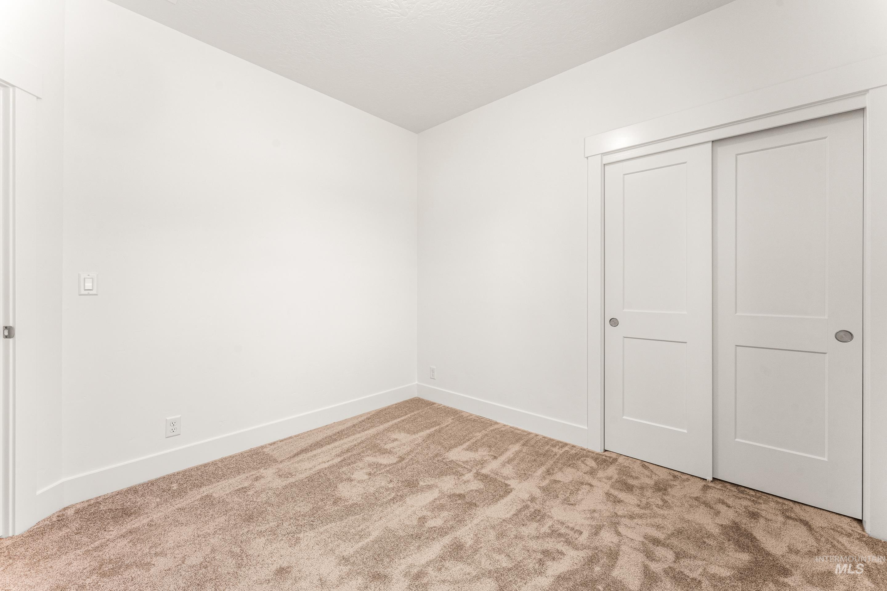 Unfurnished bedroom with light carpet and a closet