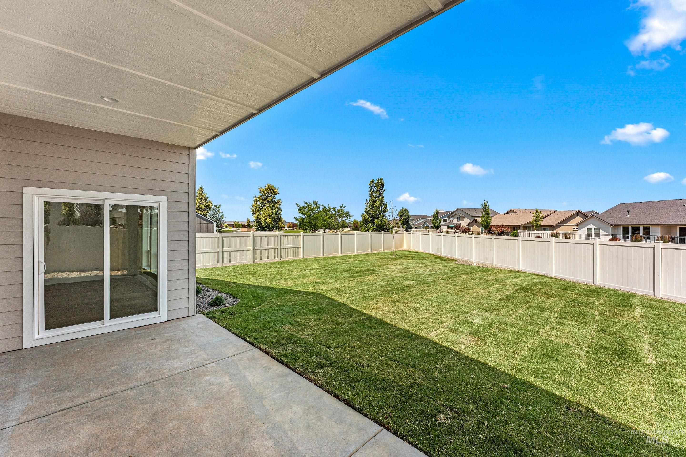 Fenced backyard with a patio area and a residential view