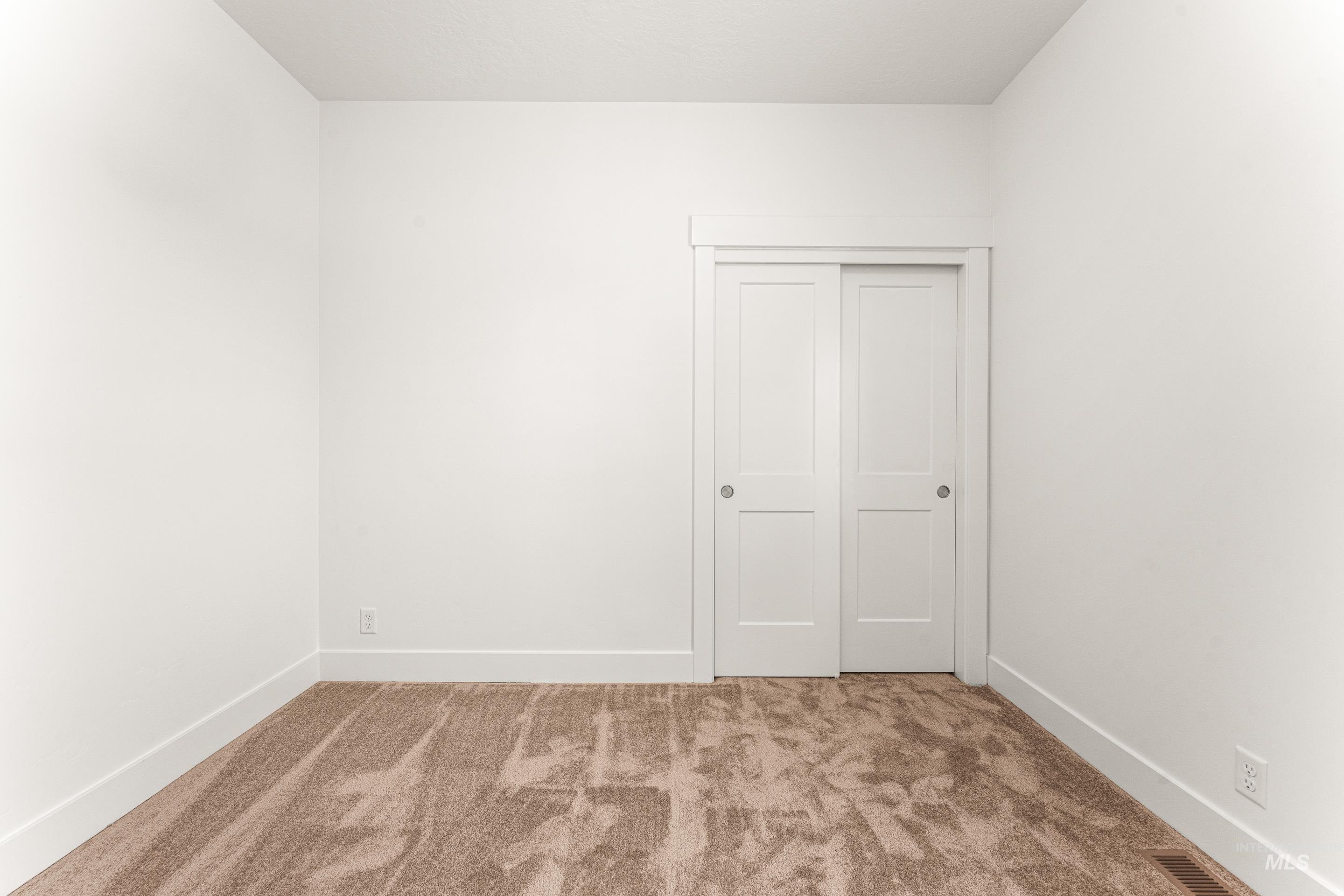 Empty room featuring carpet flooring and baseboards