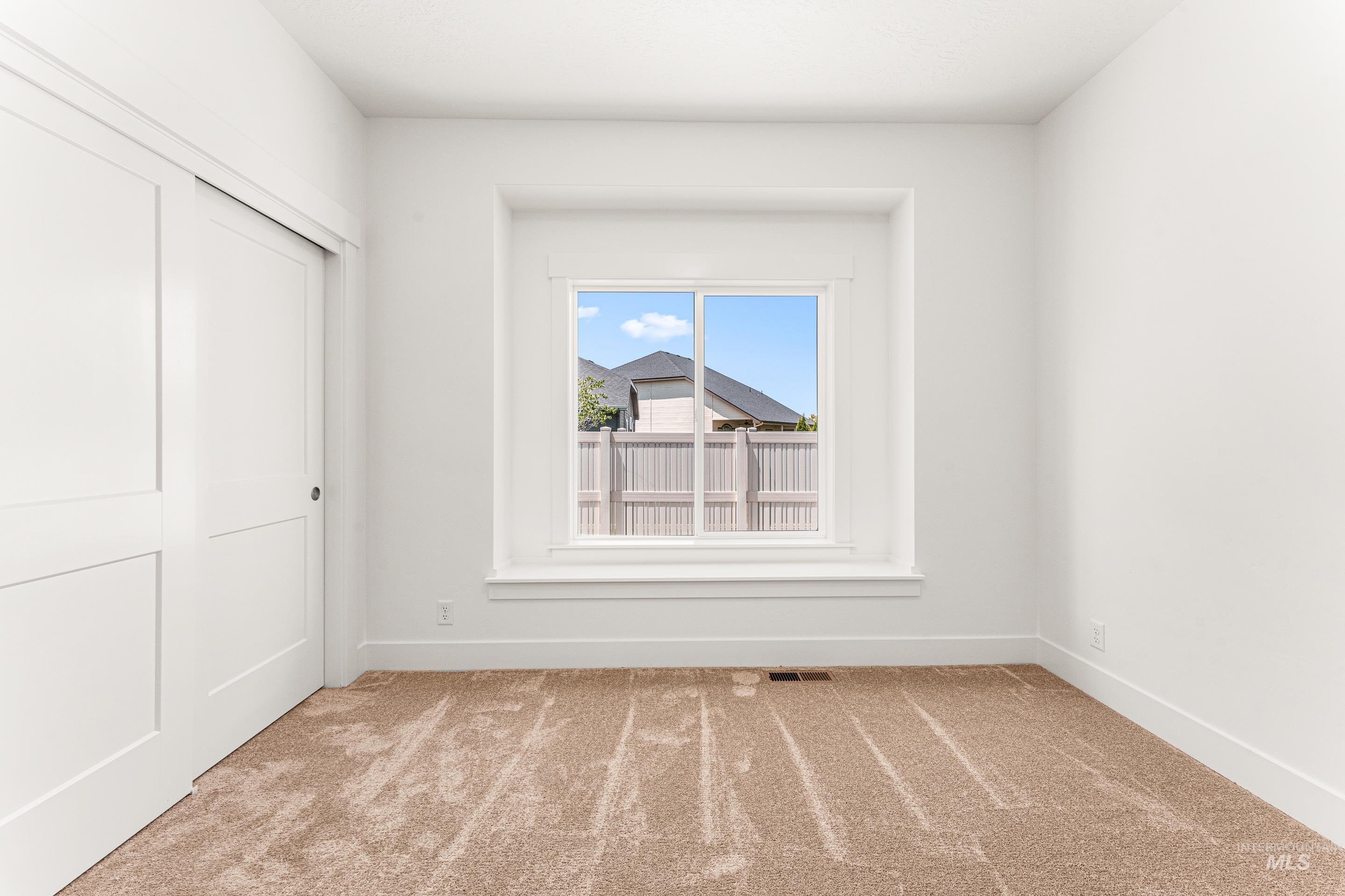 Unfurnished bedroom featuring light colored carpet and a closet