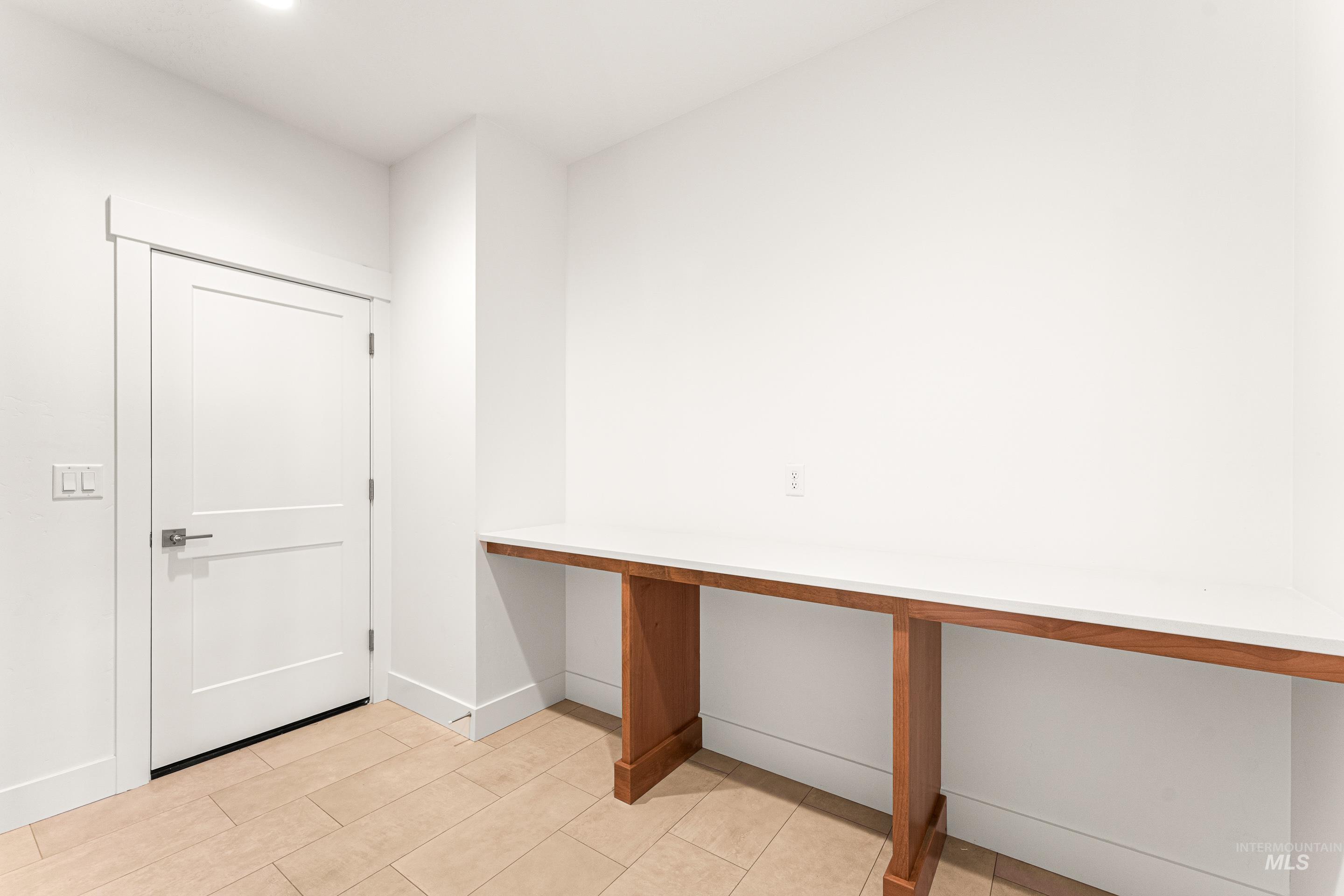 Unfurnished office featuring baseboards and light tile patterned flooring