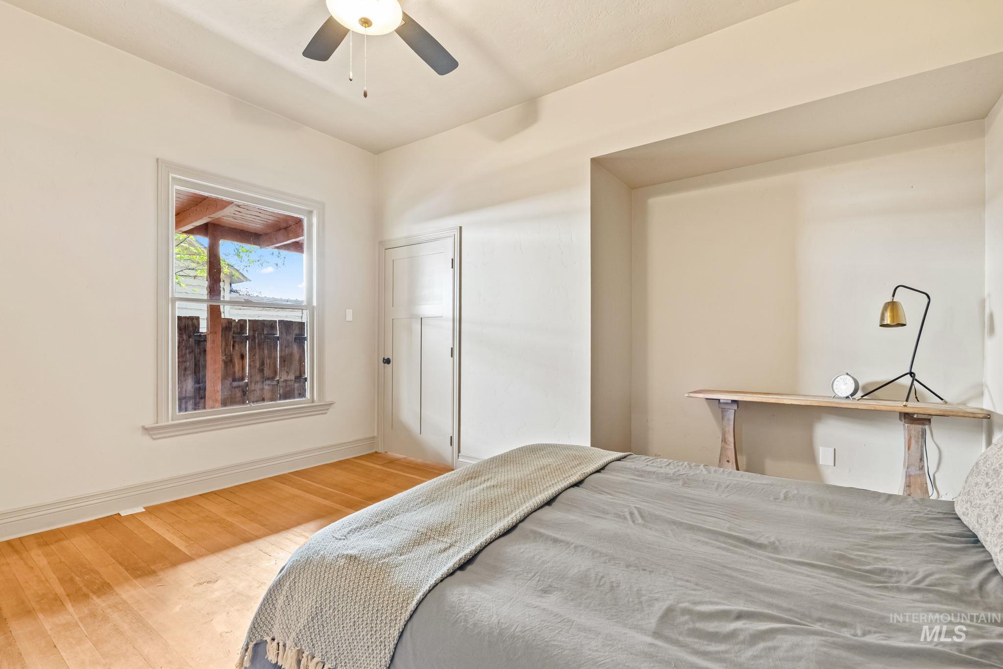 Hardwood flooring, light-toned walls, and a ceiling fan create a comfortable atmosphere