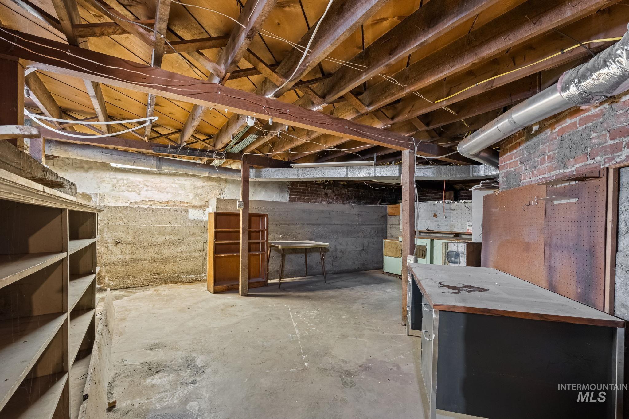Unfinished basement with exposed ceiling joists and concrete flooring