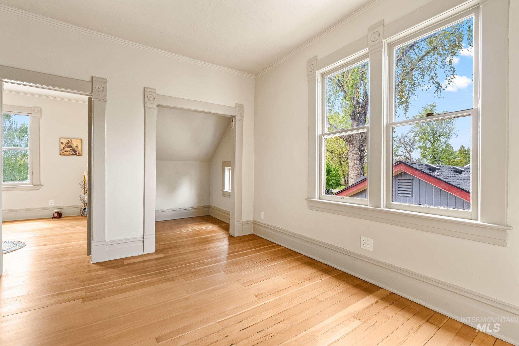 Light wood-finish flooring complements the white walls and gray trim