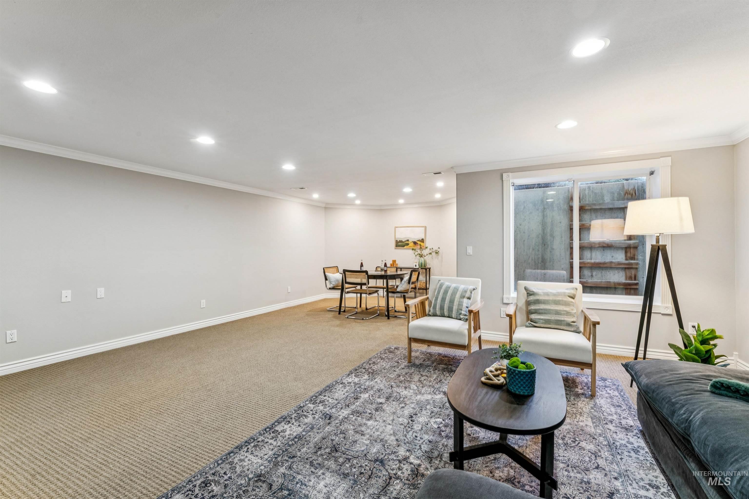 Carpeted living room with ornamental molding and recessed lighting
