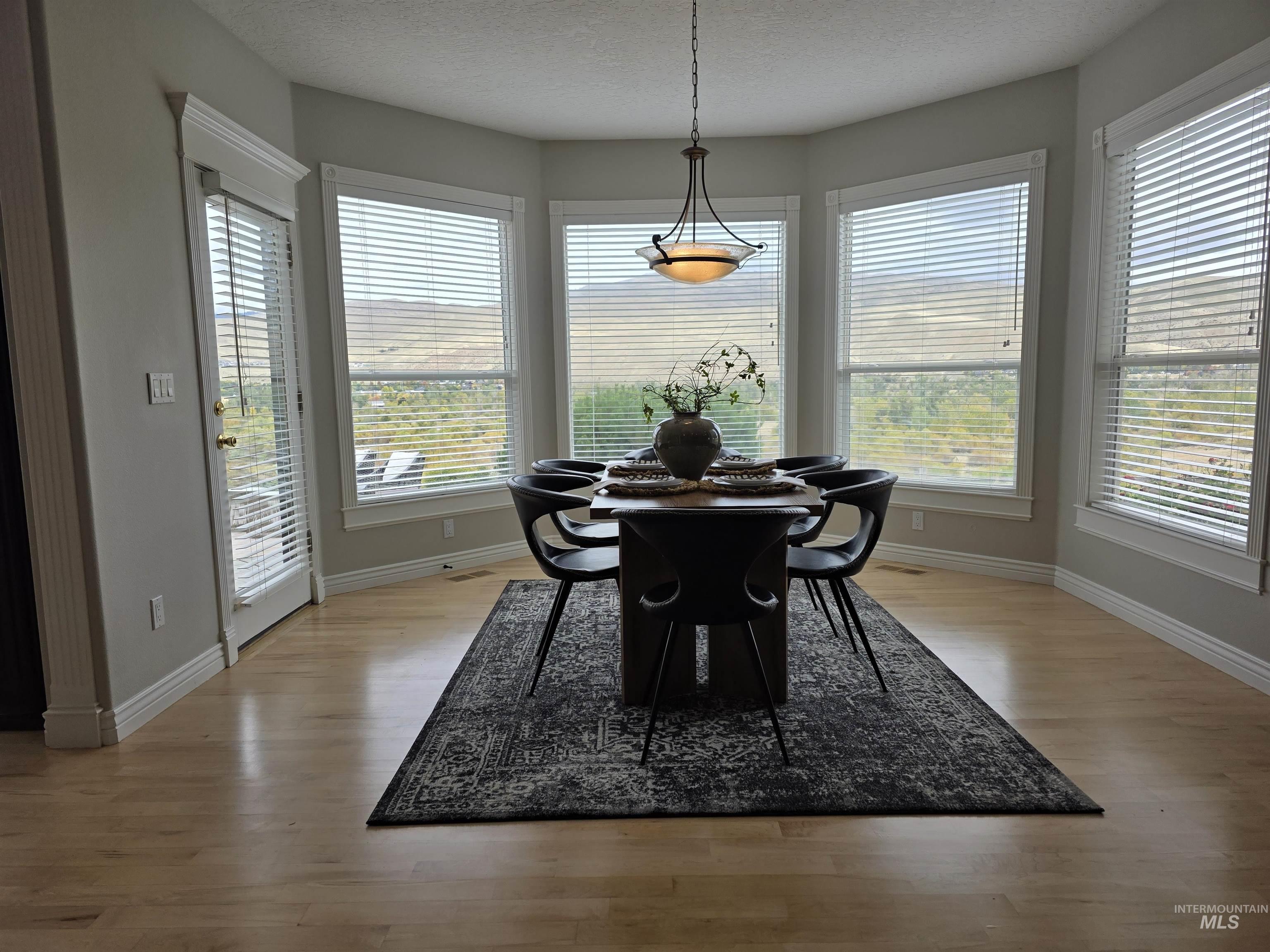 Dining space featuring a textured ceiling and light wood finished floors
