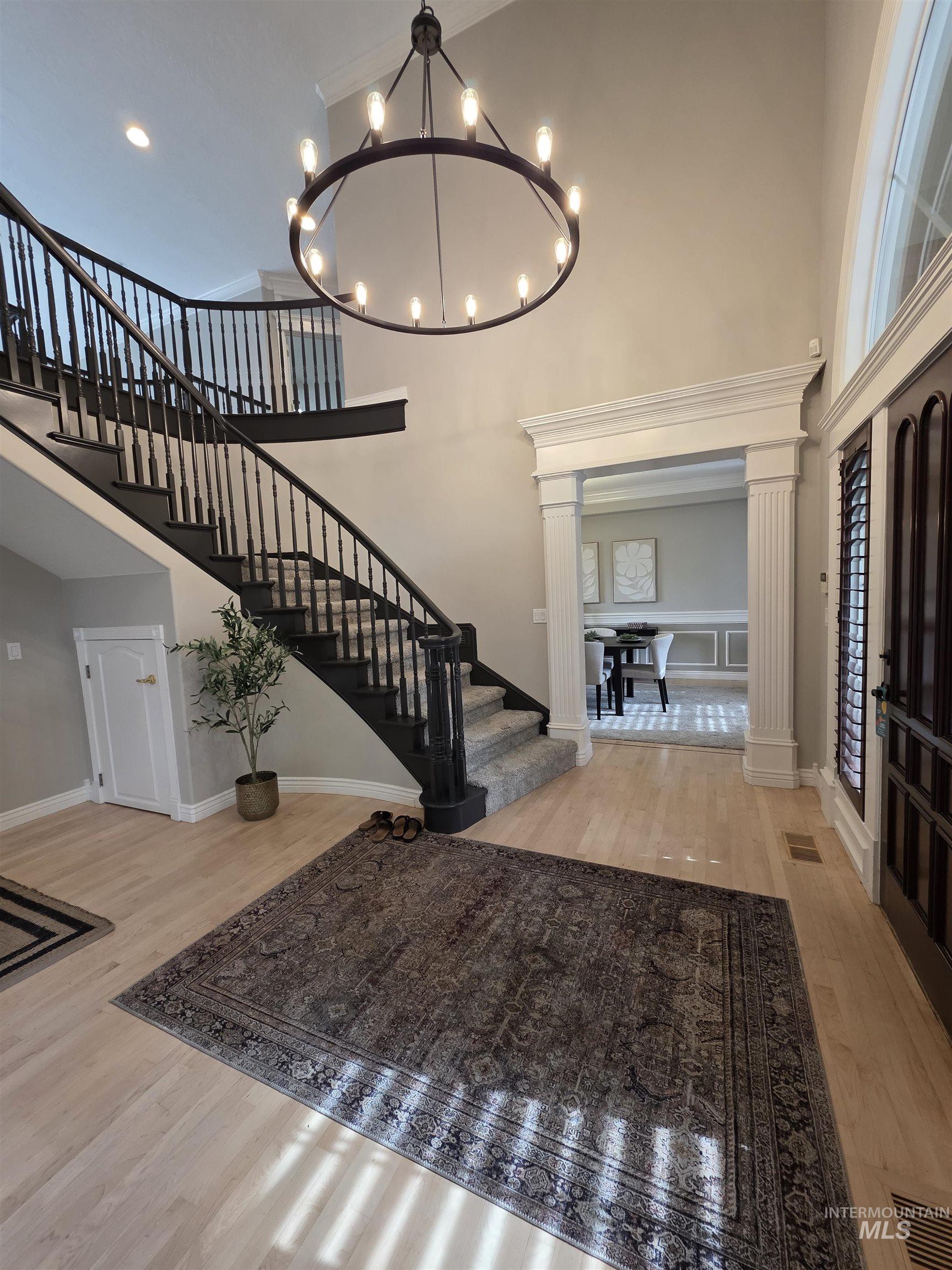 Entryway featuring stairs, light wood finished floors, a towering ceiling, a chandelier, and recessed lighting