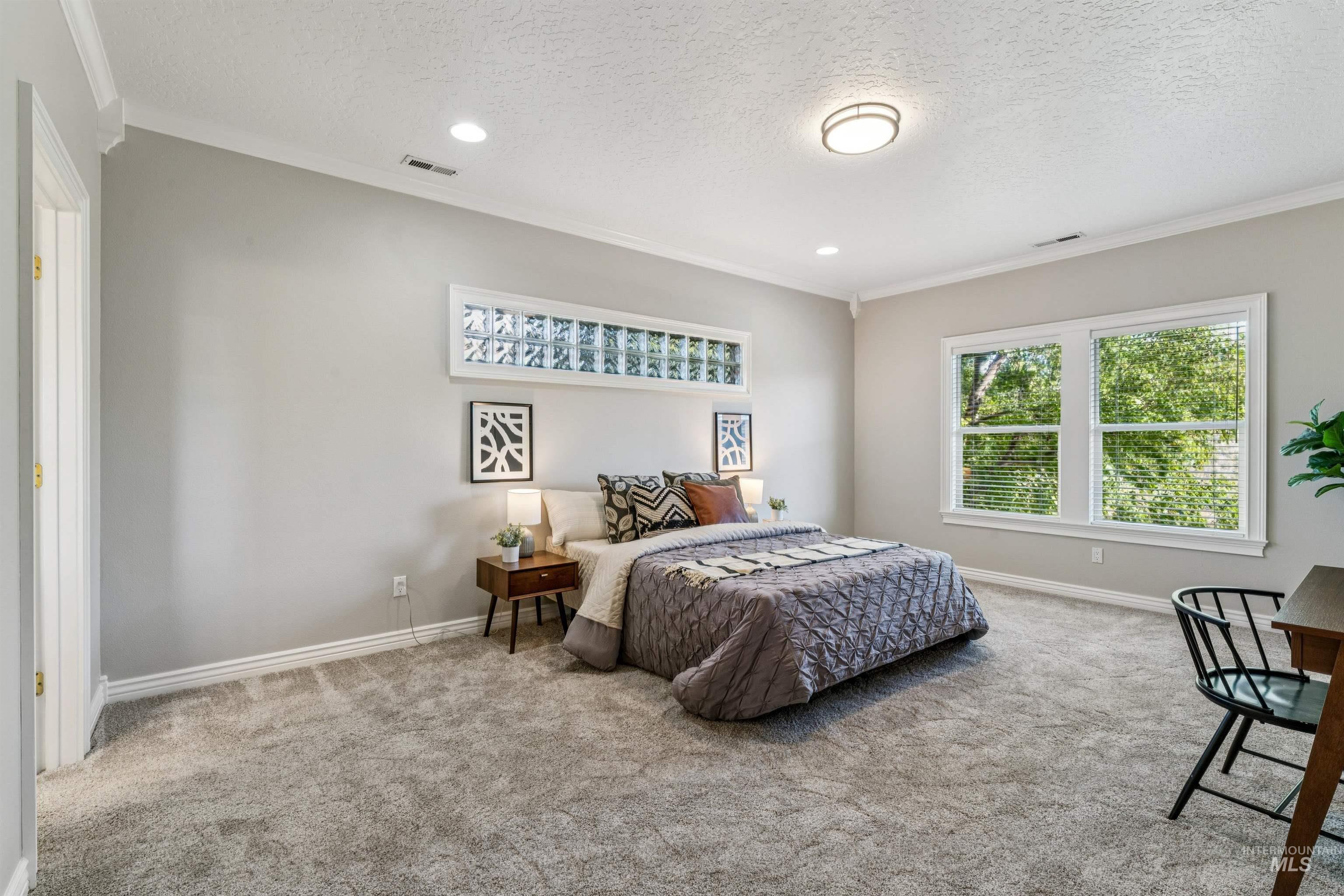 Carpeted bedroom featuring ornamental molding, a textured ceiling, and recessed lighting