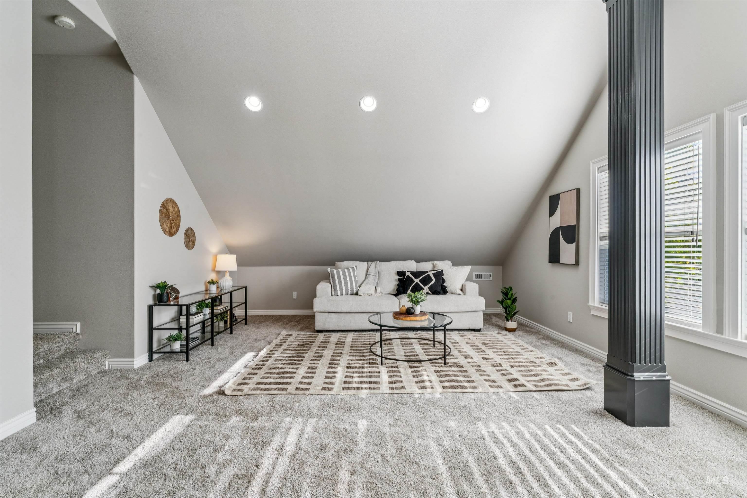 Carpeted living room with recessed lighting and vaulted ceiling