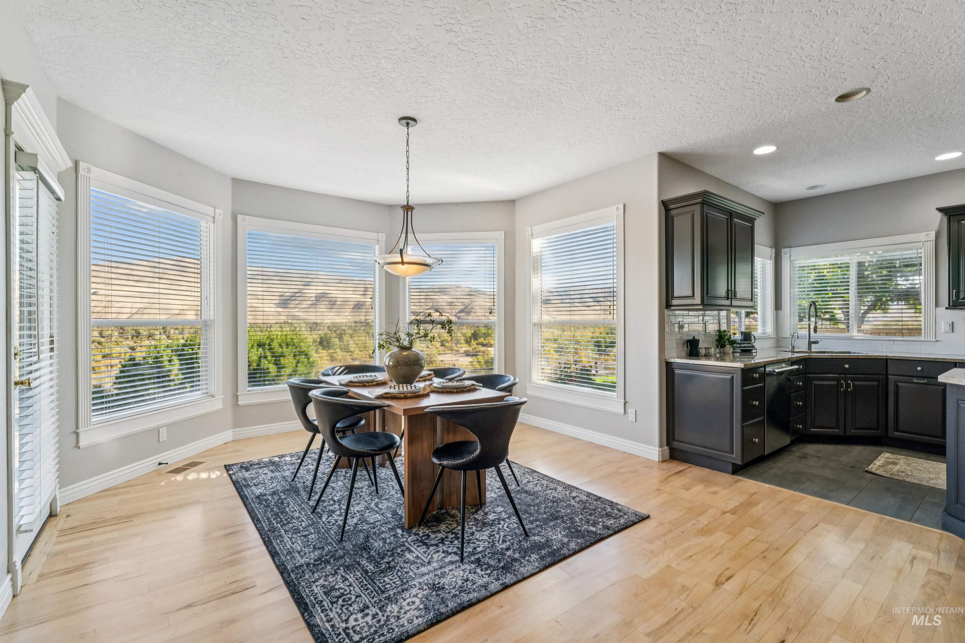 Dining space featuring a textured ceiling, dark wood-style flooring, and recessed lighting