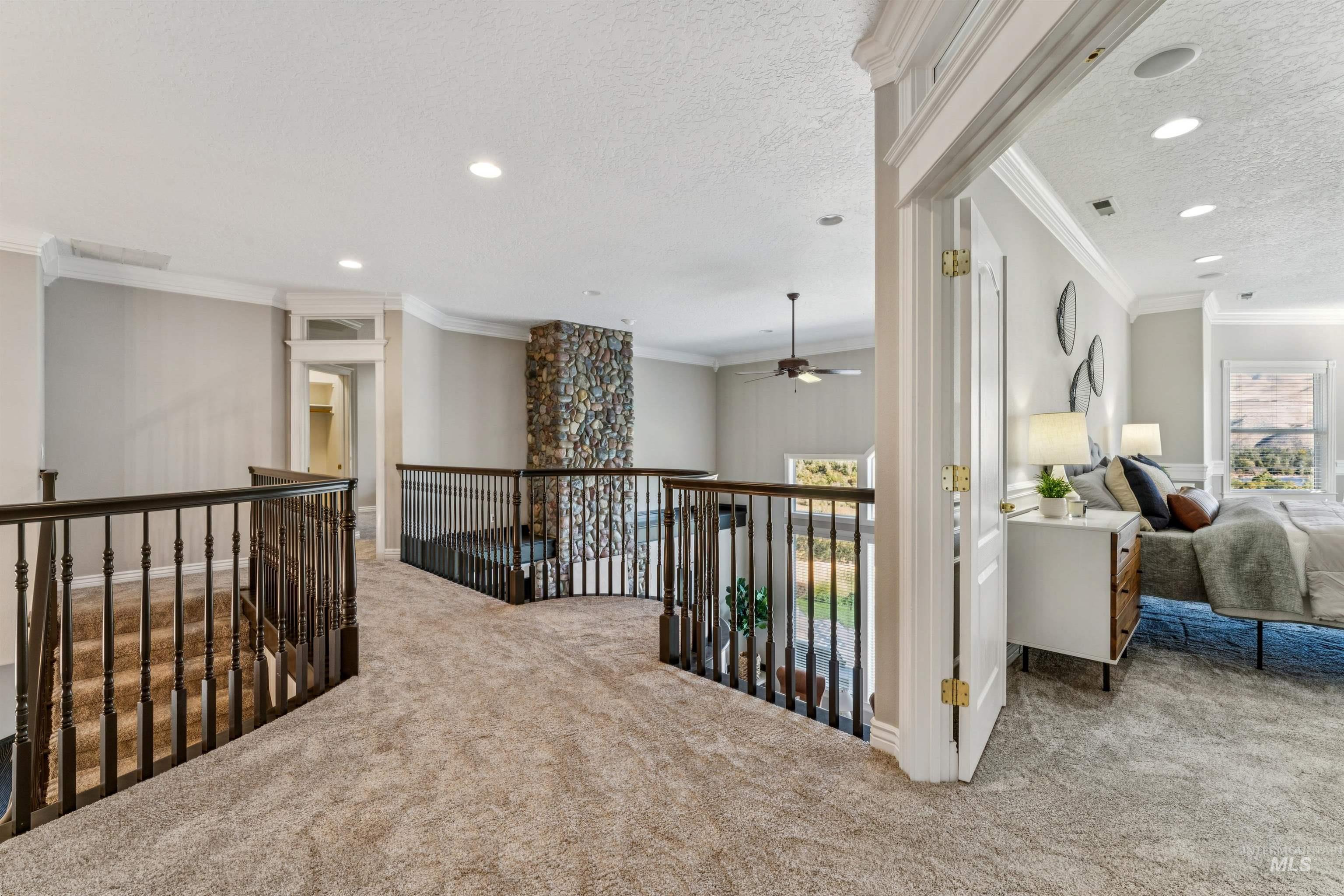 Hallway with crown molding, plenty of natural light, carpet flooring, a textured ceiling, and recessed lighting