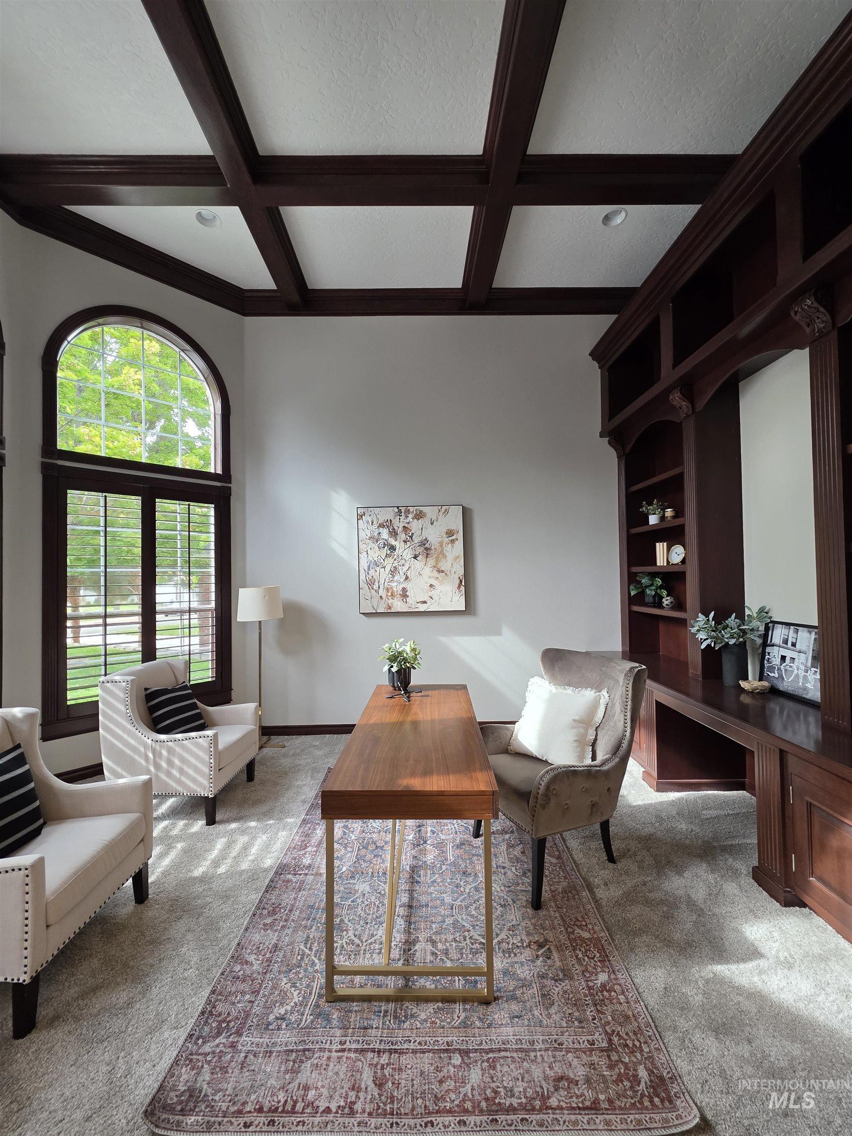 Carpeted living room with beamed ceiling, coffered ceiling, and a textured ceiling