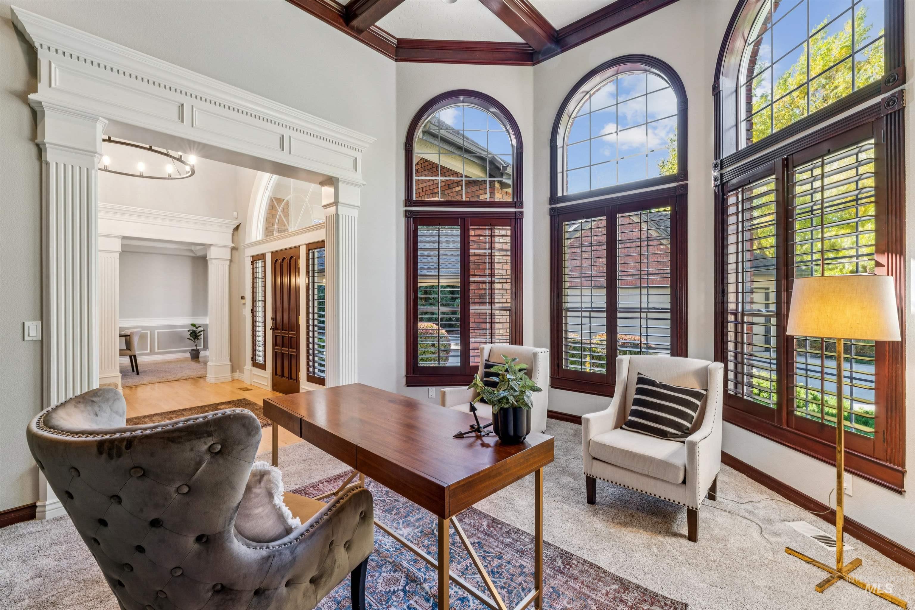 Office space with a towering ceiling, coffered ceiling, beam ceiling, and carpet
