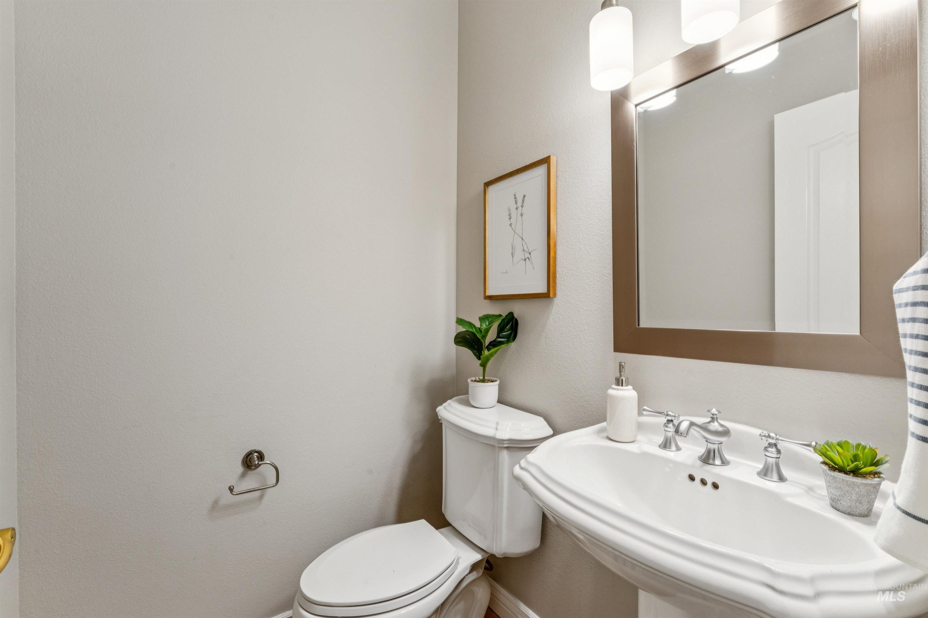 Half bath featuring a sink and a textured wall