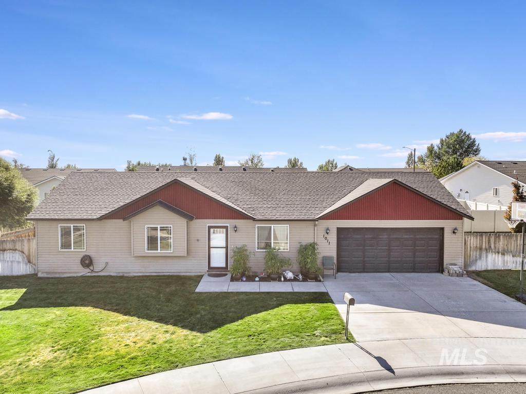 Single story home featuring an attached garage, driveway, and roof with shingles