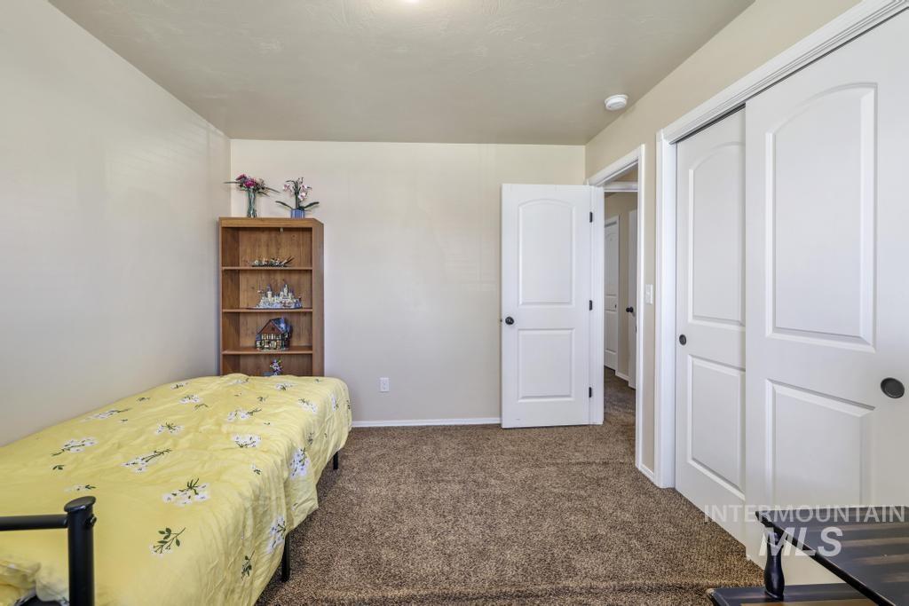Carpeted bedroom with baseboards and a closet