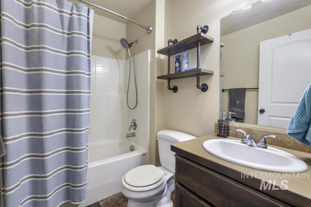 Bathroom with shower / bath combo with shower curtain and vanity