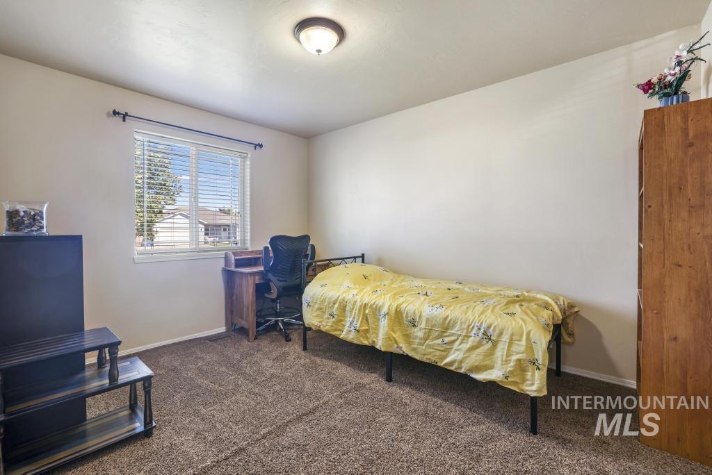 Bedroom featuring dark colored carpet and baseboards