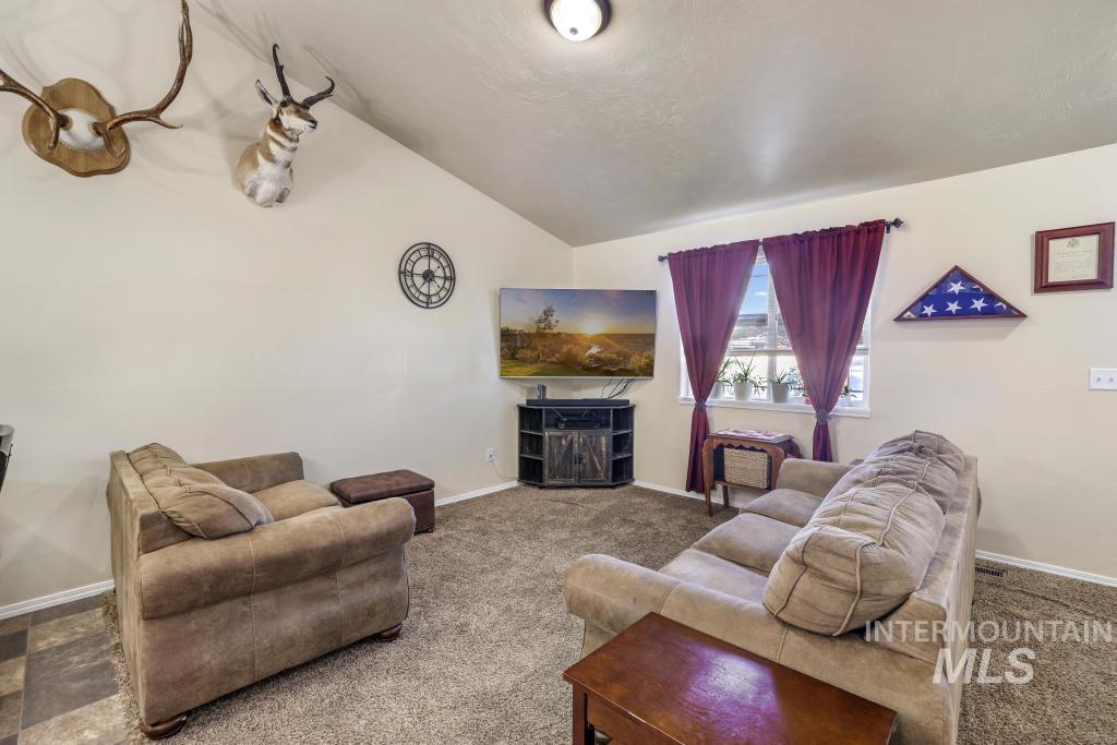 Living area featuring vaulted ceiling and carpet