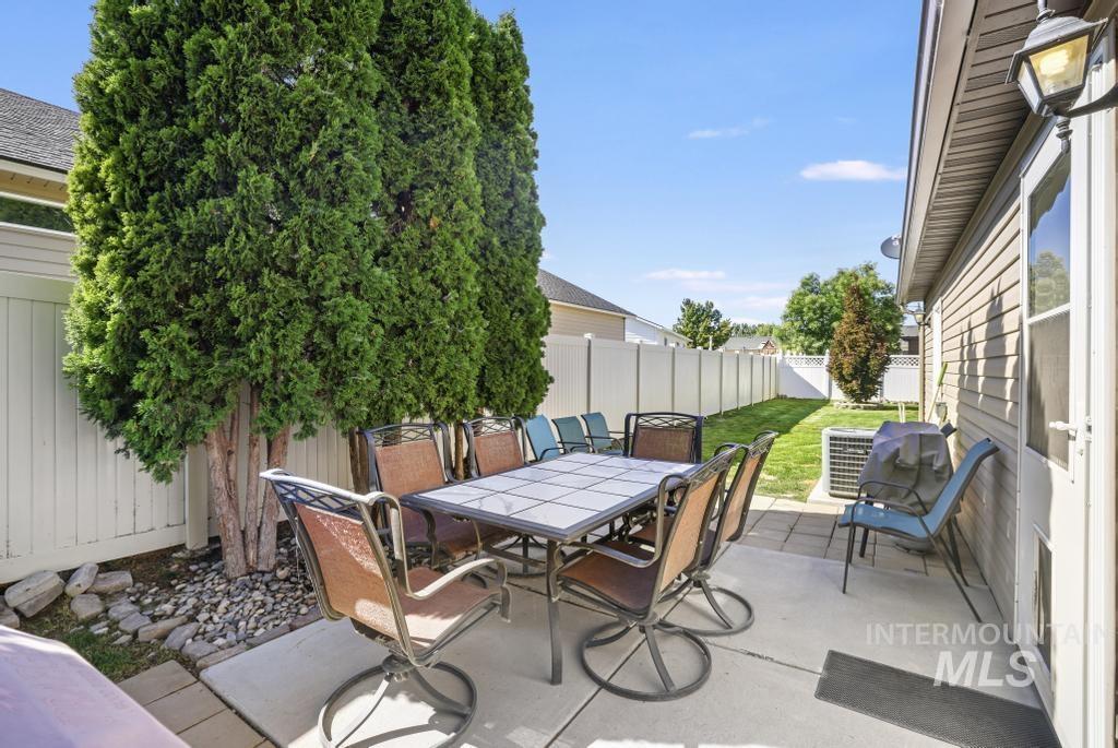Fenced backyard with a patio, outdoor dining area, and a grill