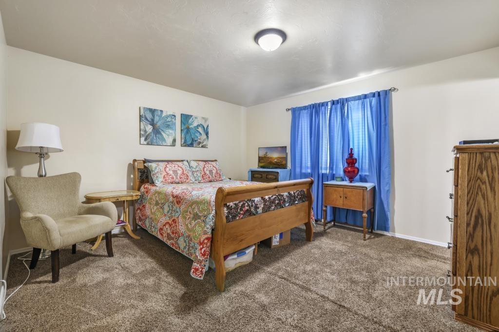 Bedroom featuring carpet and baseboards